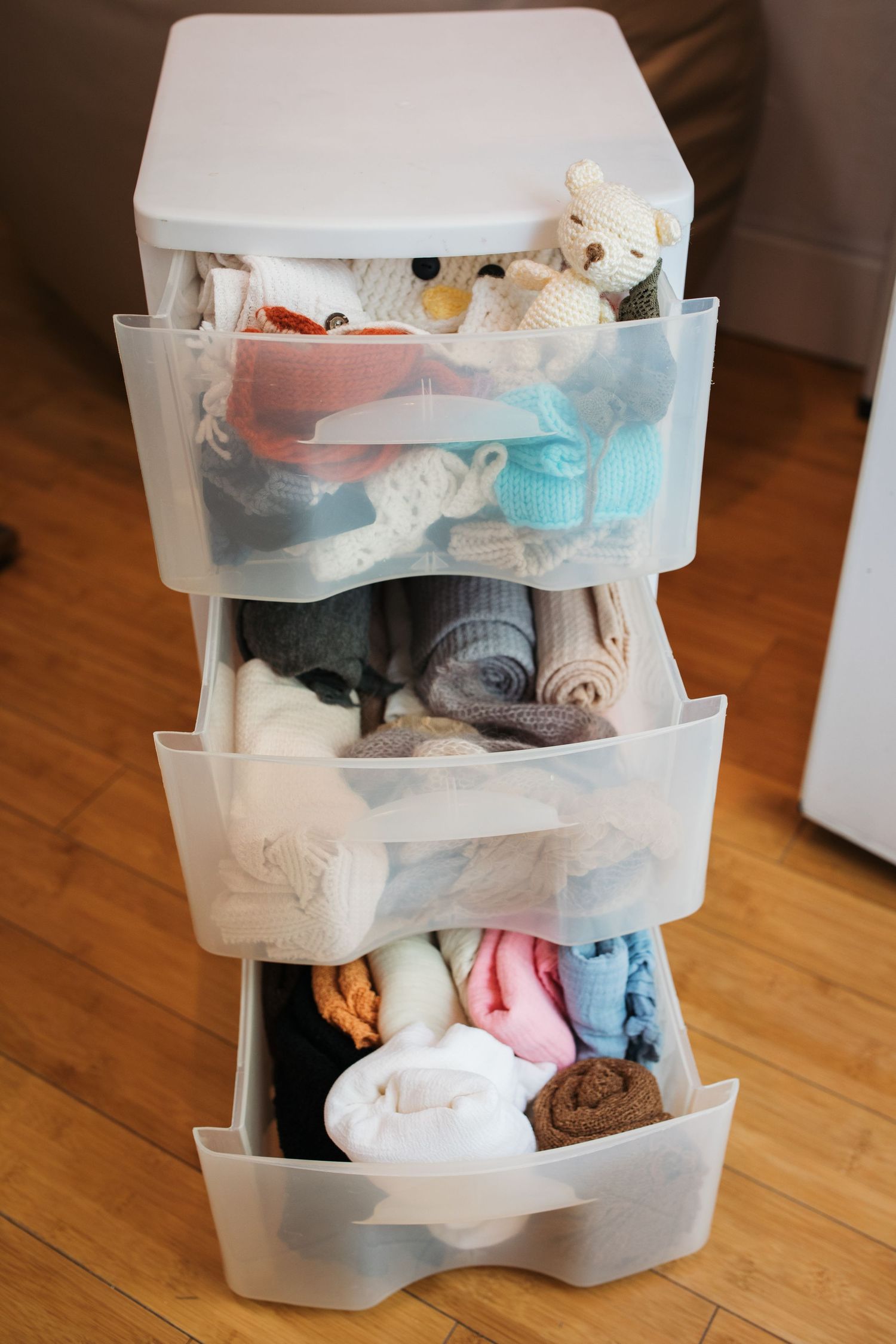 Organized newborn photography wraps, hats, and props stored in the studio.