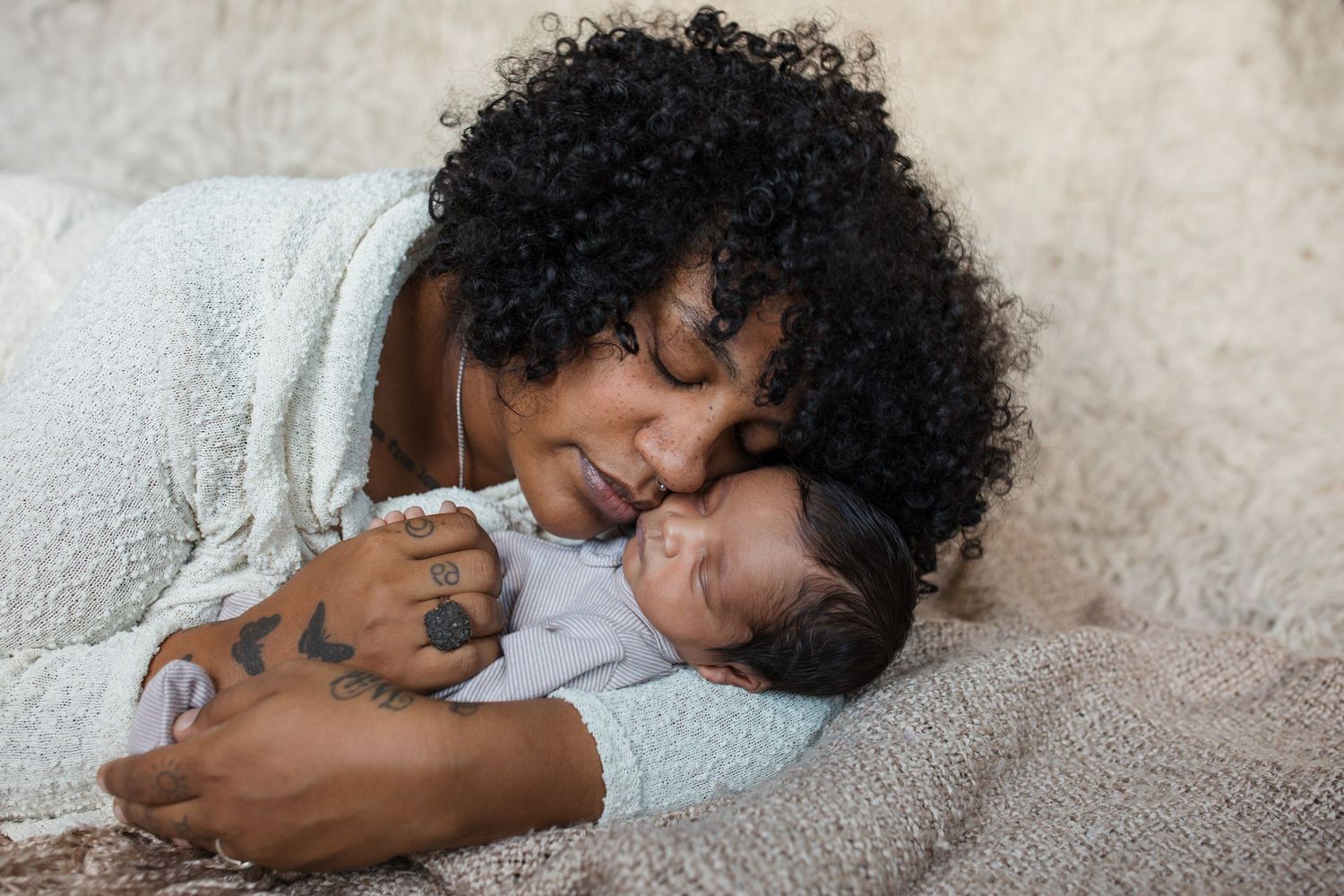 Mother cuddling her newborn baby during a cozy lifestyle newborn photography session in the Treasure Valley.