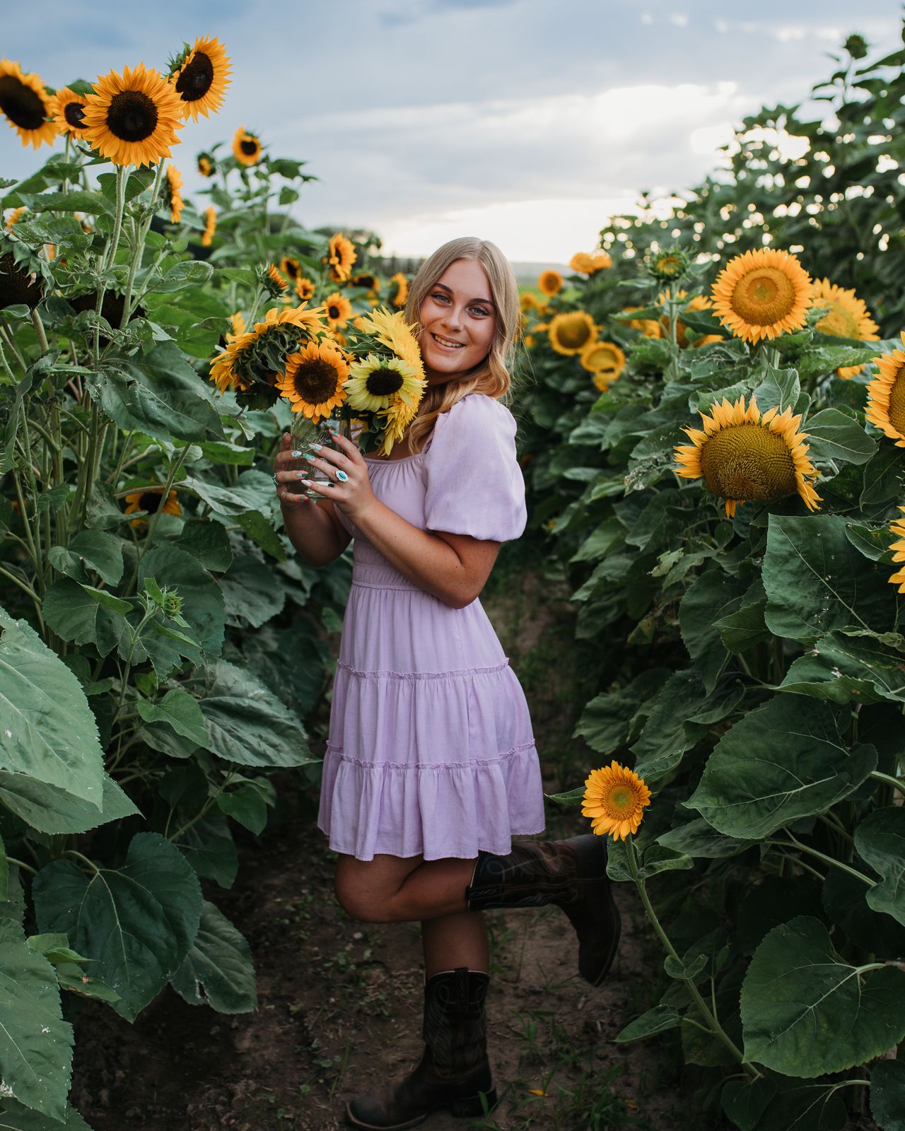 A sunflower field at sunset with tall green stalks and vibrant yellow blooms stretching into the distance - Senior photos nampa Idaho