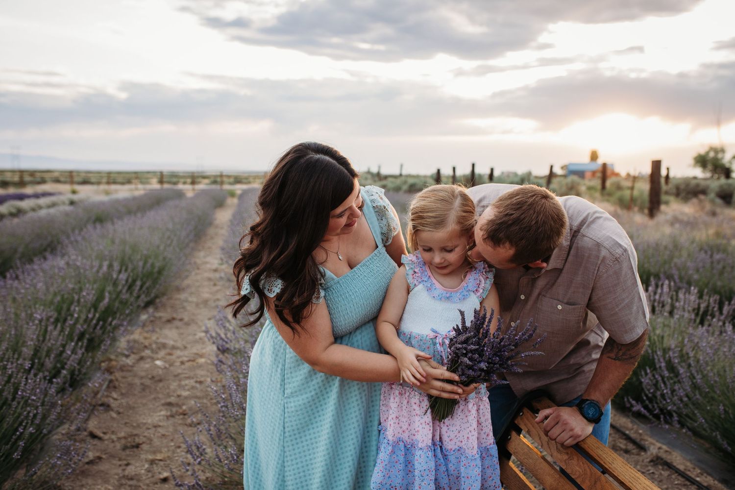 Family enjoying a summer lavender photo session in an Idaho lavender field during golden hour with blooming purple rows.