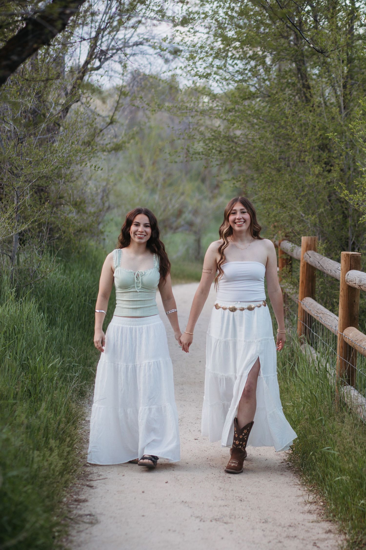 Two high school seniors walking together on path during Boise senior photo session