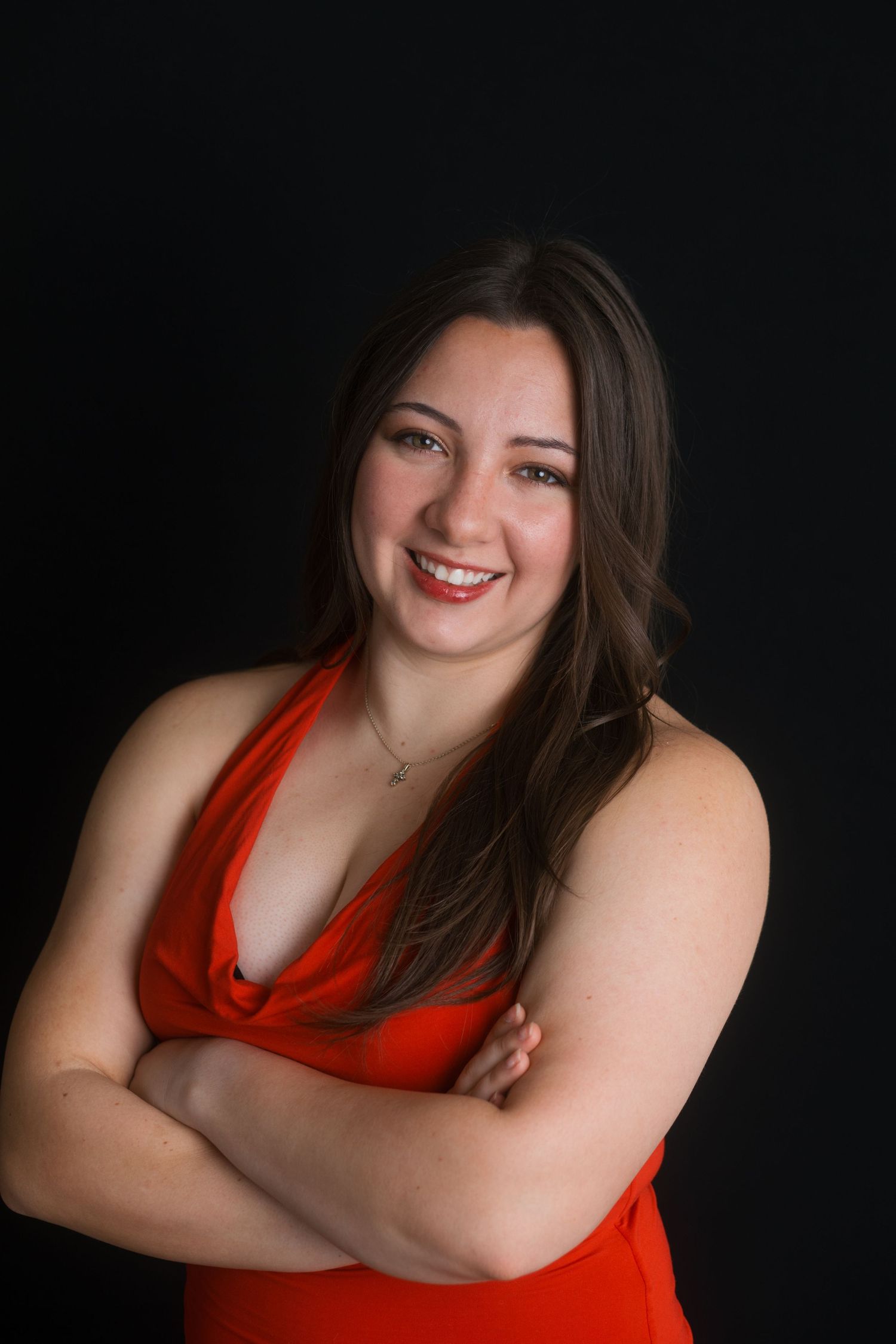 Confident studio headshot of woman in red dress with natural expression, Boise Idaho photographer