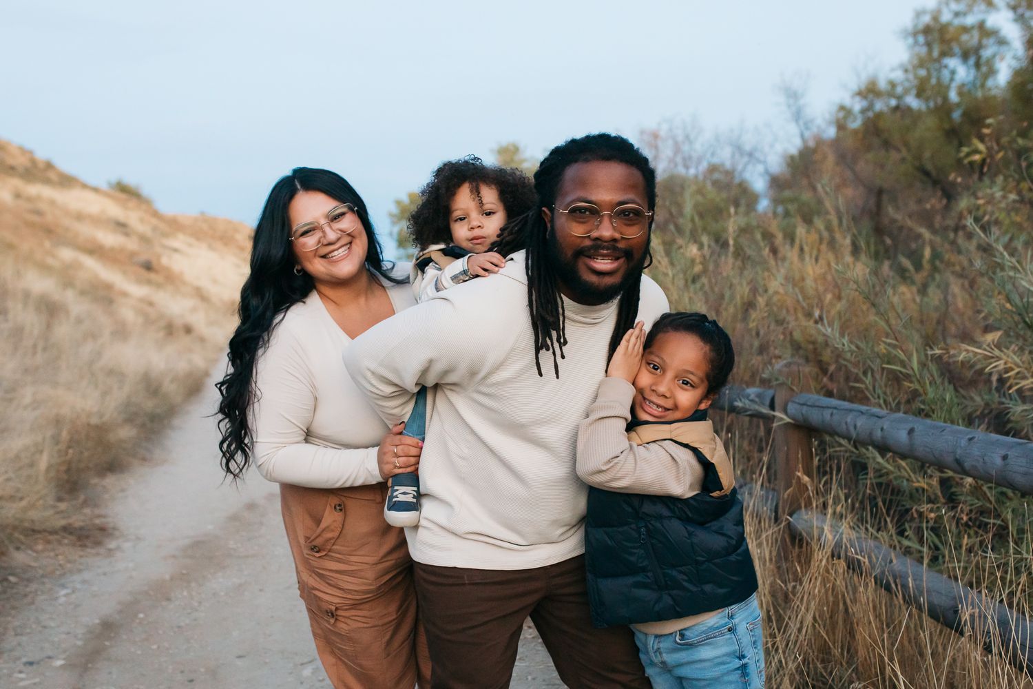 A family enjoys quality time together outdoors on a scenic hiking trail during golden hour - lifestyle family photos in Boise