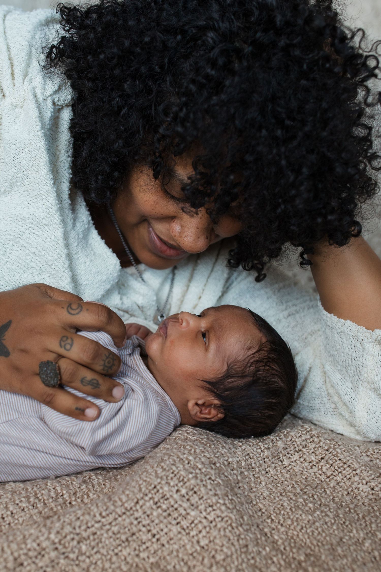 Tender moment between mother and newborn baby during lifestyle newborn photography session in Boise Idaho.