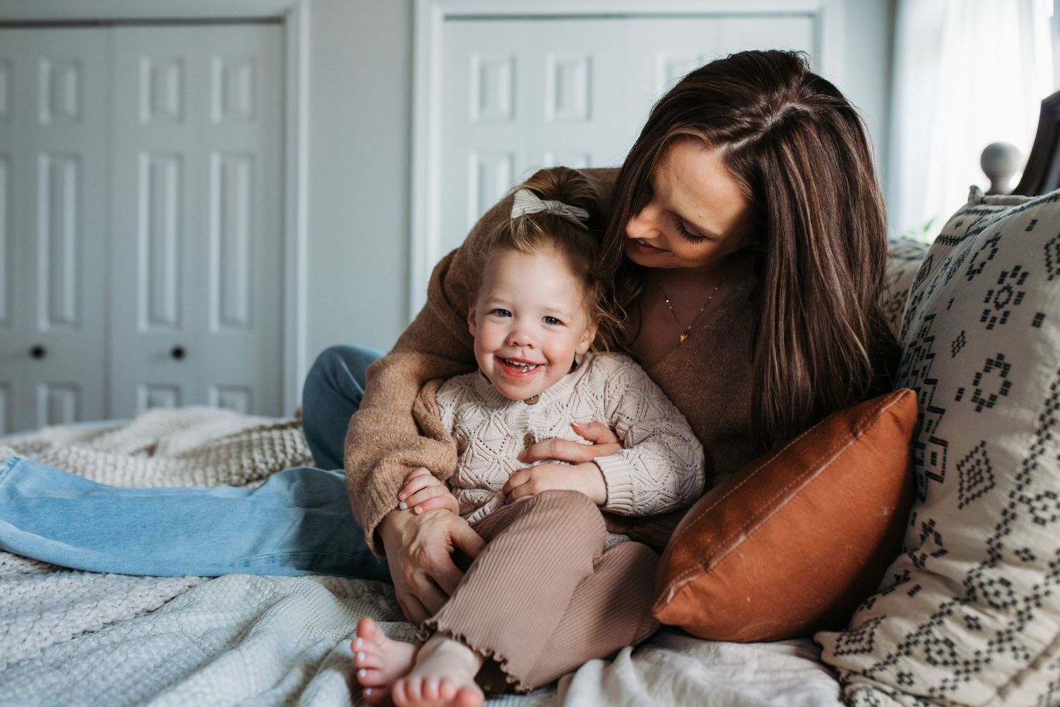 A collection of intimate family moments showing parent and child cuddling together on soft bedding -in-home lifestyle family photos Boise