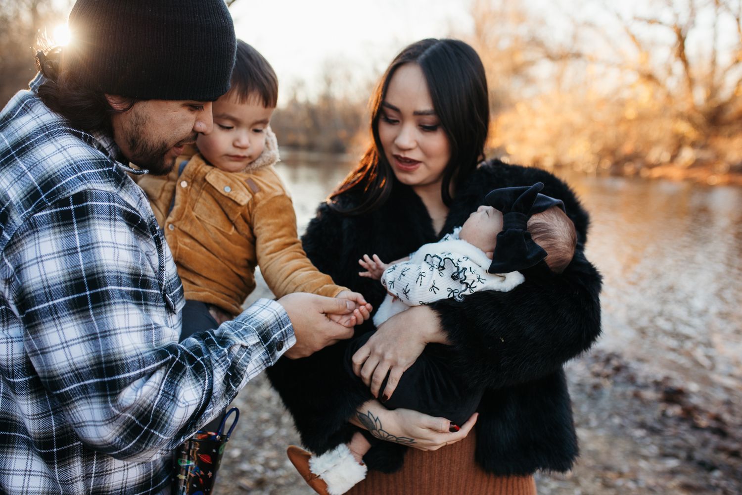 Family sharing tender moments together during a sunset photoshoot by a river in autumn - lifestyle family photos in Boise