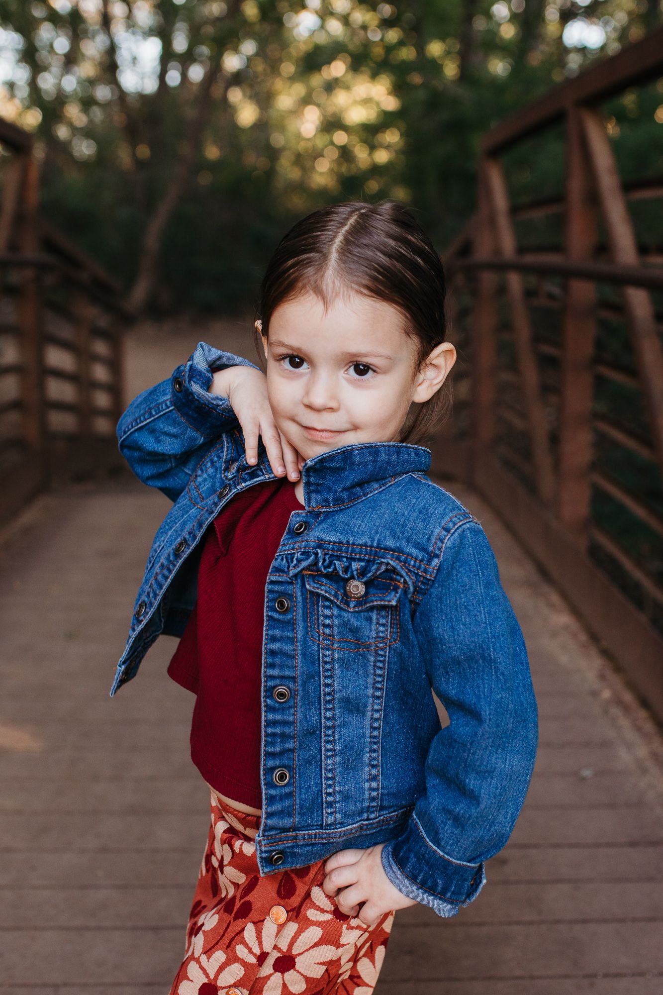 photos showing a child in a denim jacket and floral dress posing on a wooden bridge birthday milestone photos Middleton Idaho