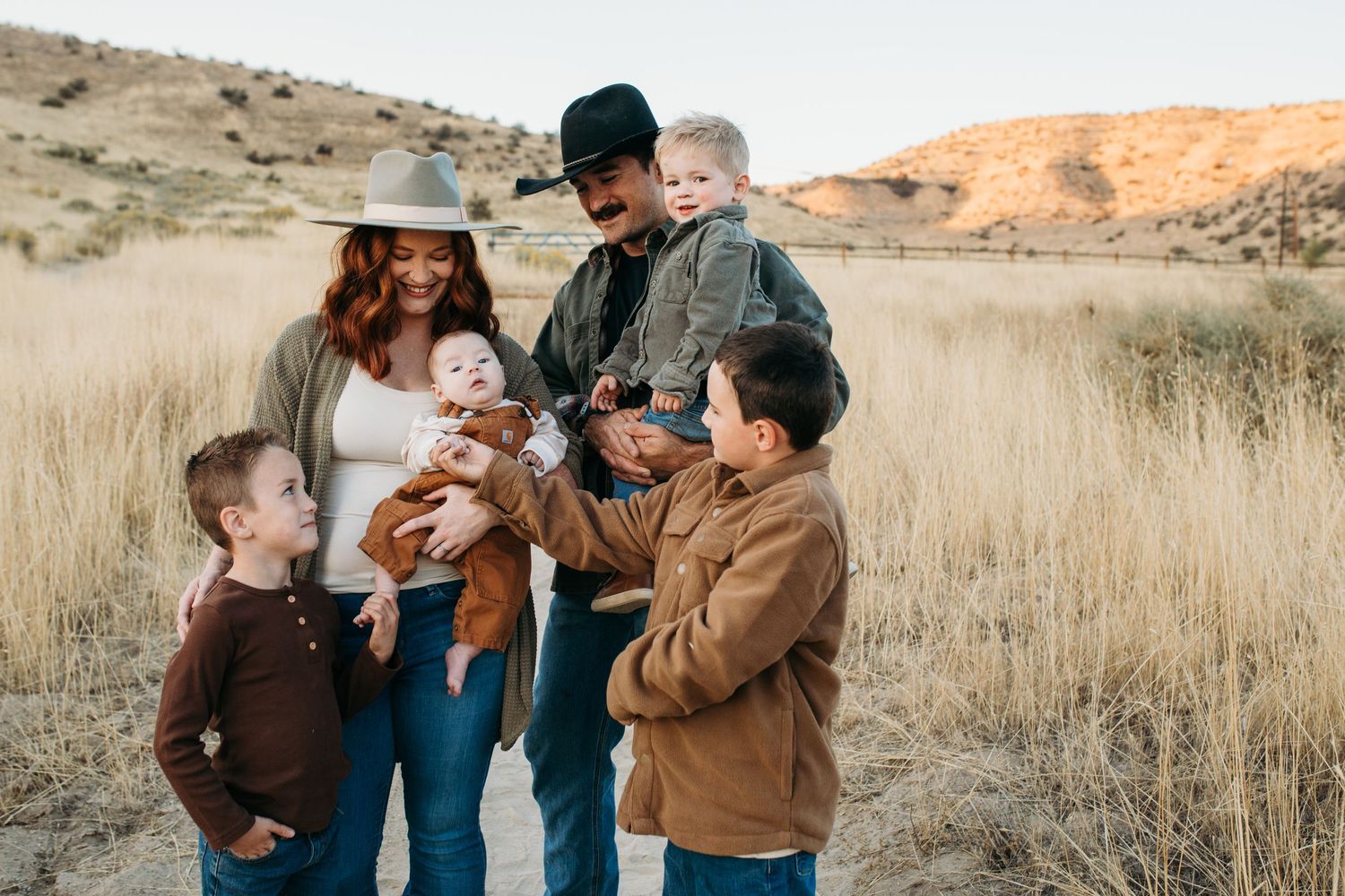 A family shares joyful moments together in a golden autumn field at sunset - lifestyle family photos in Boise