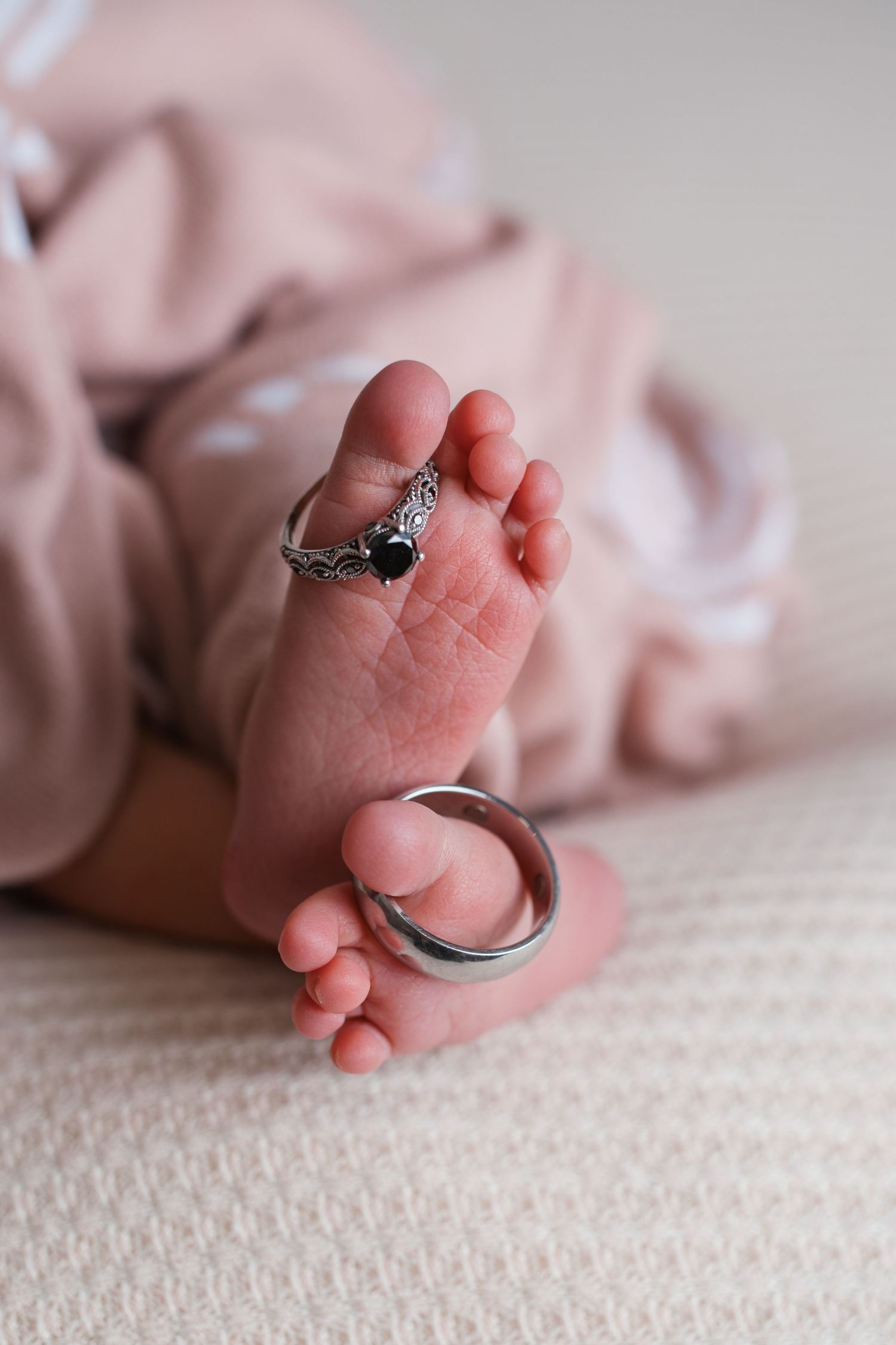 Close up of newborn baby feet with sentimental jewelry during a studio newborn session in Nampa, Idaho.