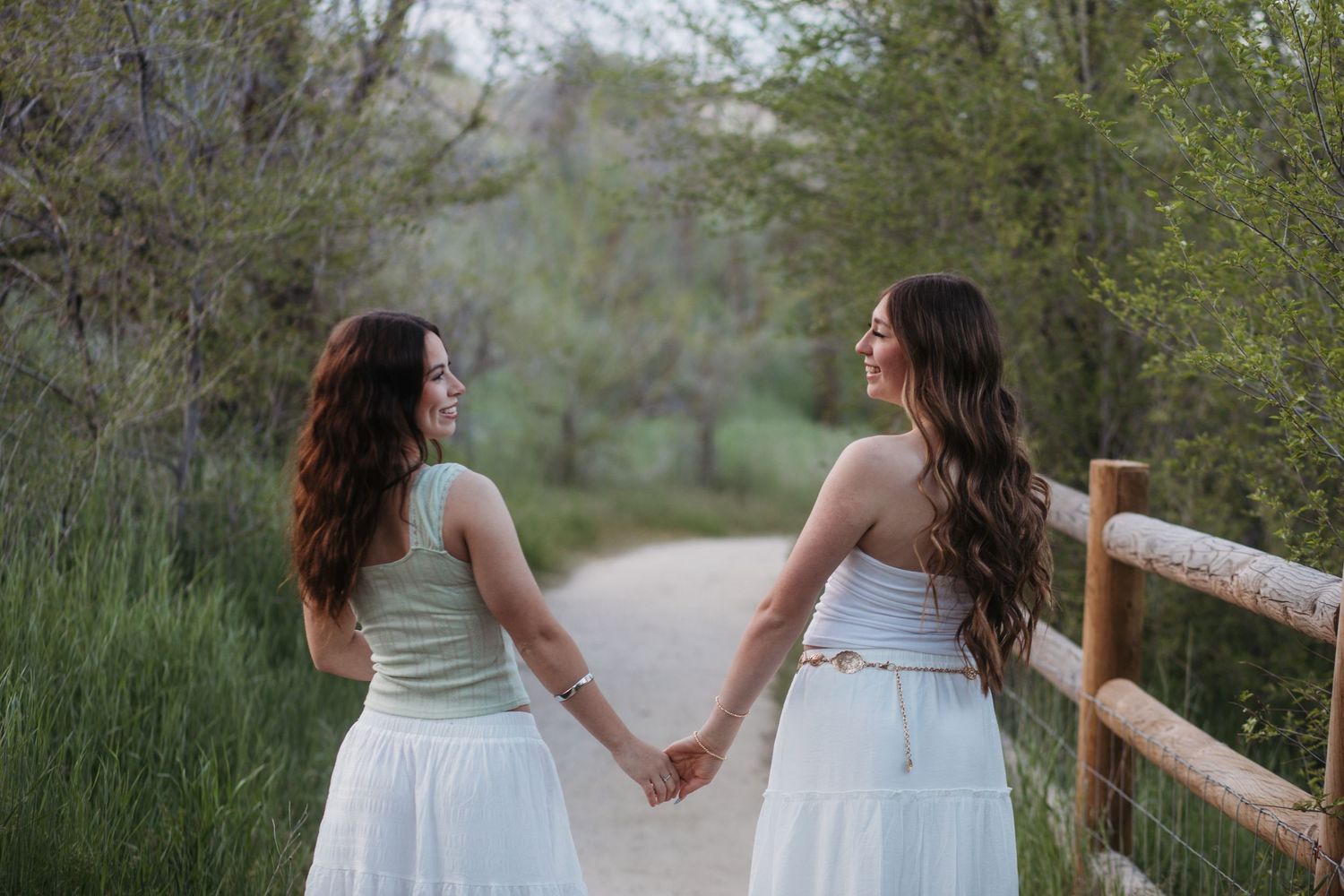 Senior girls walking together in a field at sunset during Boise senior photos