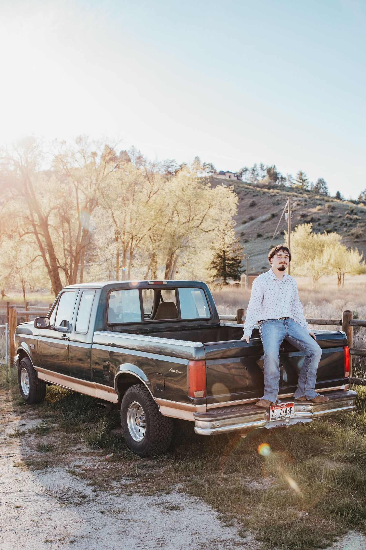 High school senior sitting on truck bed during golden hour outdoor Boise Idaho senior photo session