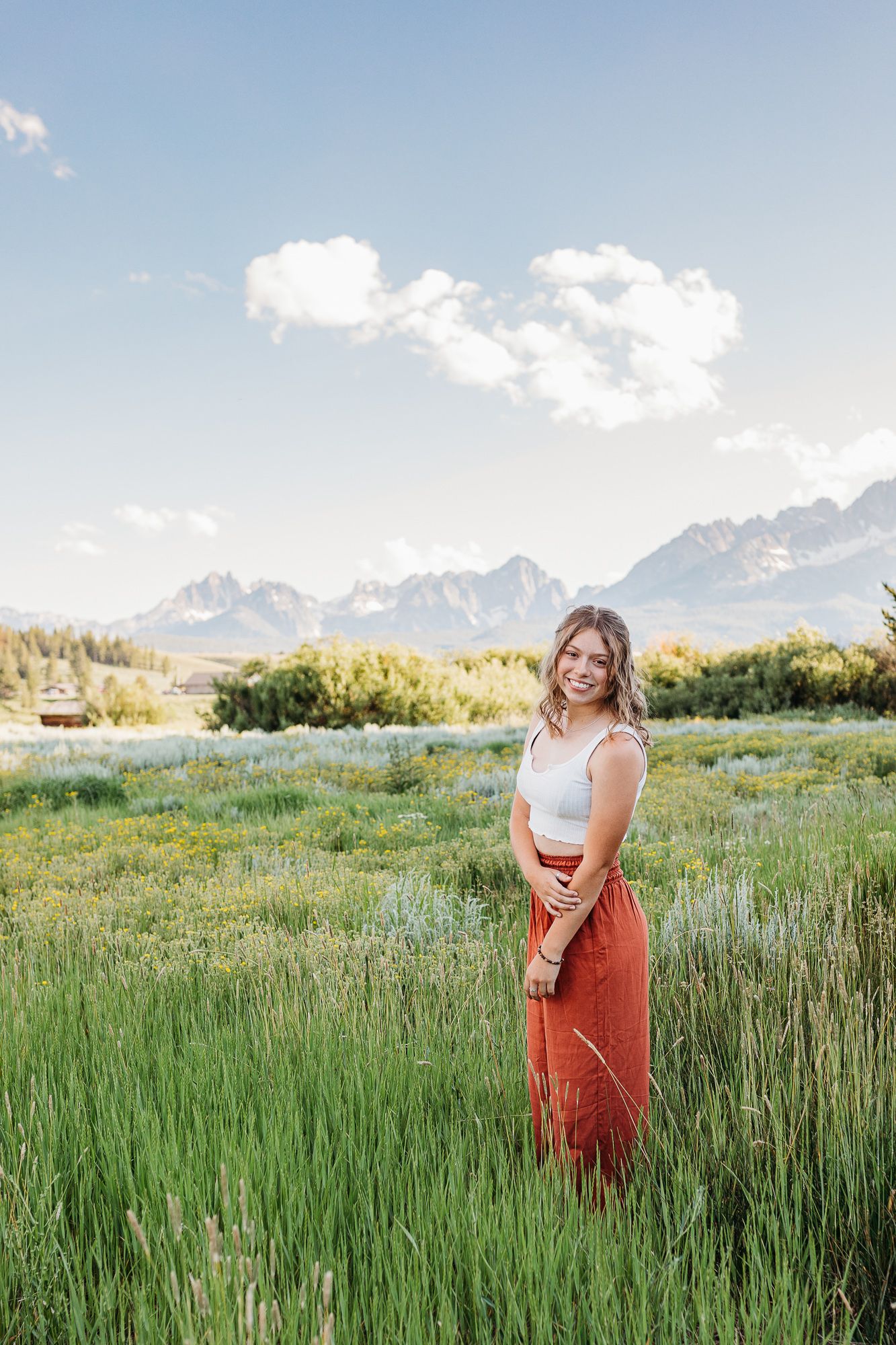 Outdoor summer senior photos in Boise Idaho featuring mountain field backdrop
