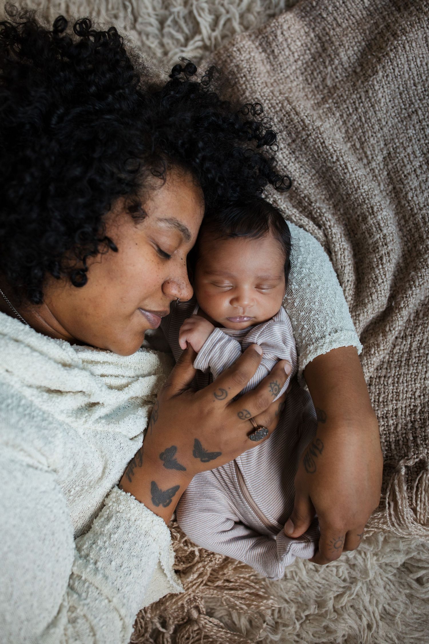 Mother holding her sleeping newborn baby during a cozy lifestyle newborn photography session in the Treasure Valley.
