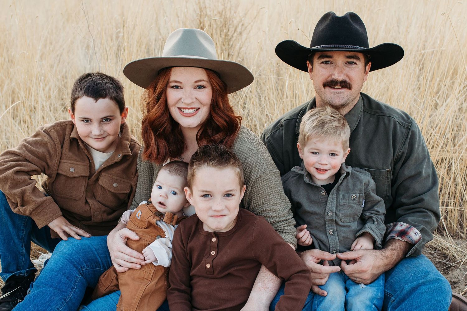 A family wearing coordinated brown and blue outfits poses together for a series of casual outdoor portrait photographs - lifestyle family