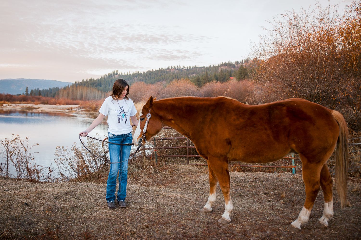 High school senior walking horse during outdoor senior photo session in Idaho
