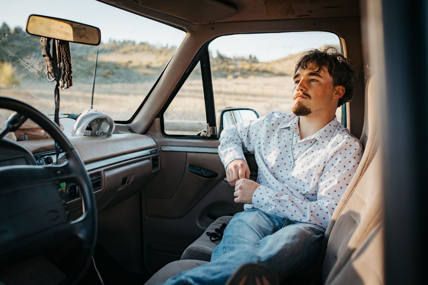 High school senior sitting in truck looking out window during Boise Idaho senior photo session