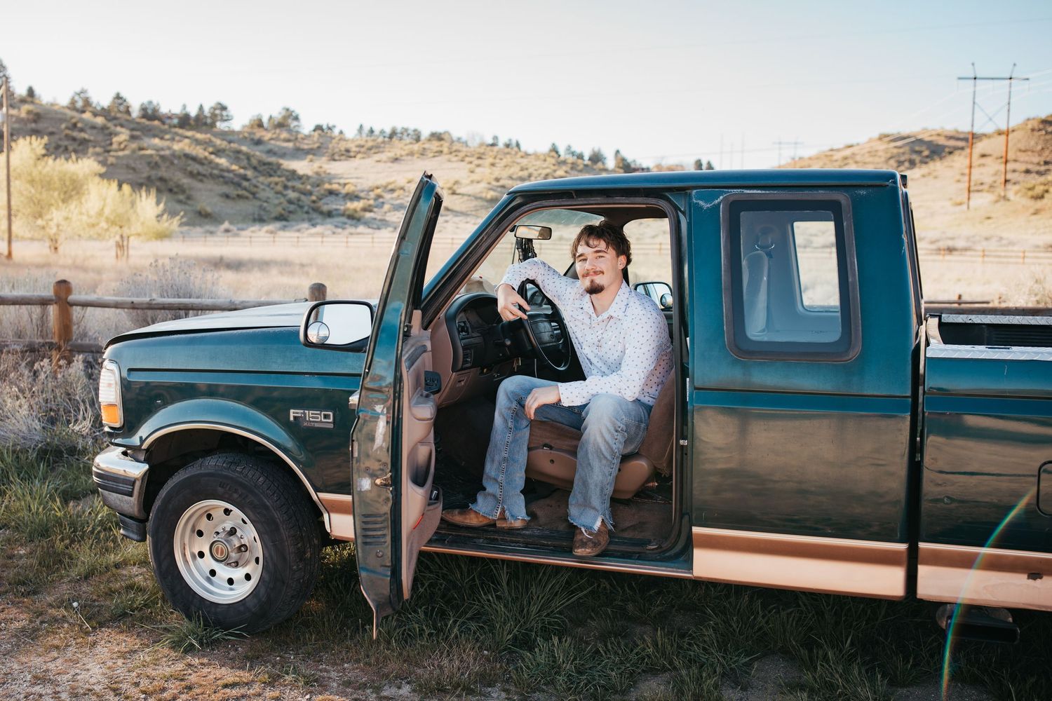 High school senior sitting in truck during outdoor Boise Idaho senior photo session with vintage pickup