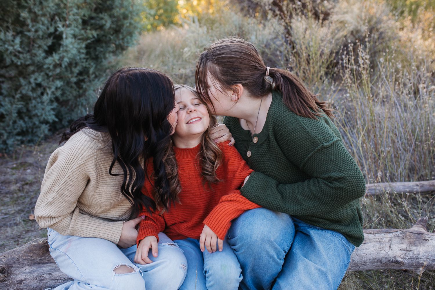 3 sisters play together outdoors in casual clothing during a golden hour photoshoot session. Boise foothills family photography