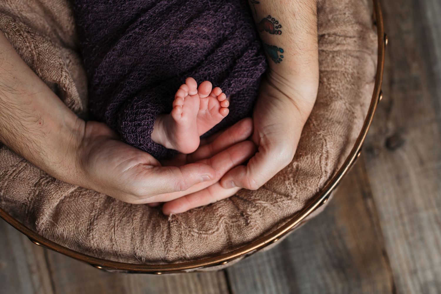 Tiny newborn baby feet resting in a parent’s hands during a studio newborn session in Nampa, Idaho