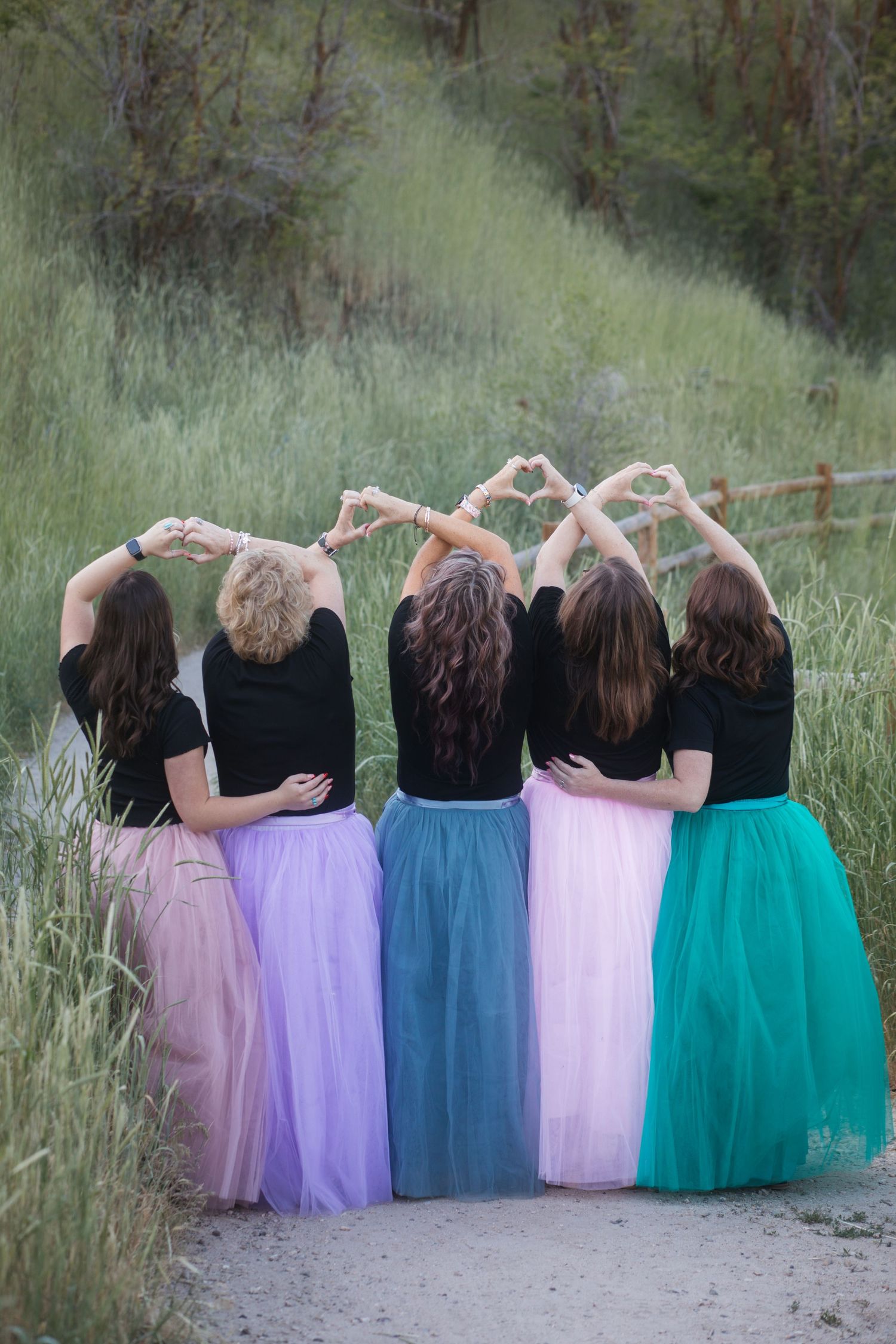 Five sisters forming heart shapes with their arms during a summer photo session at Camel's Back Park in Boise, Idaho.