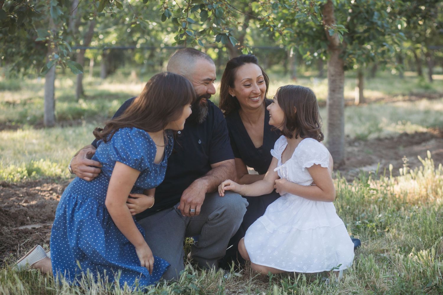 Family laughing together during a relaxed late spring orchard session in Boise, Idaho.