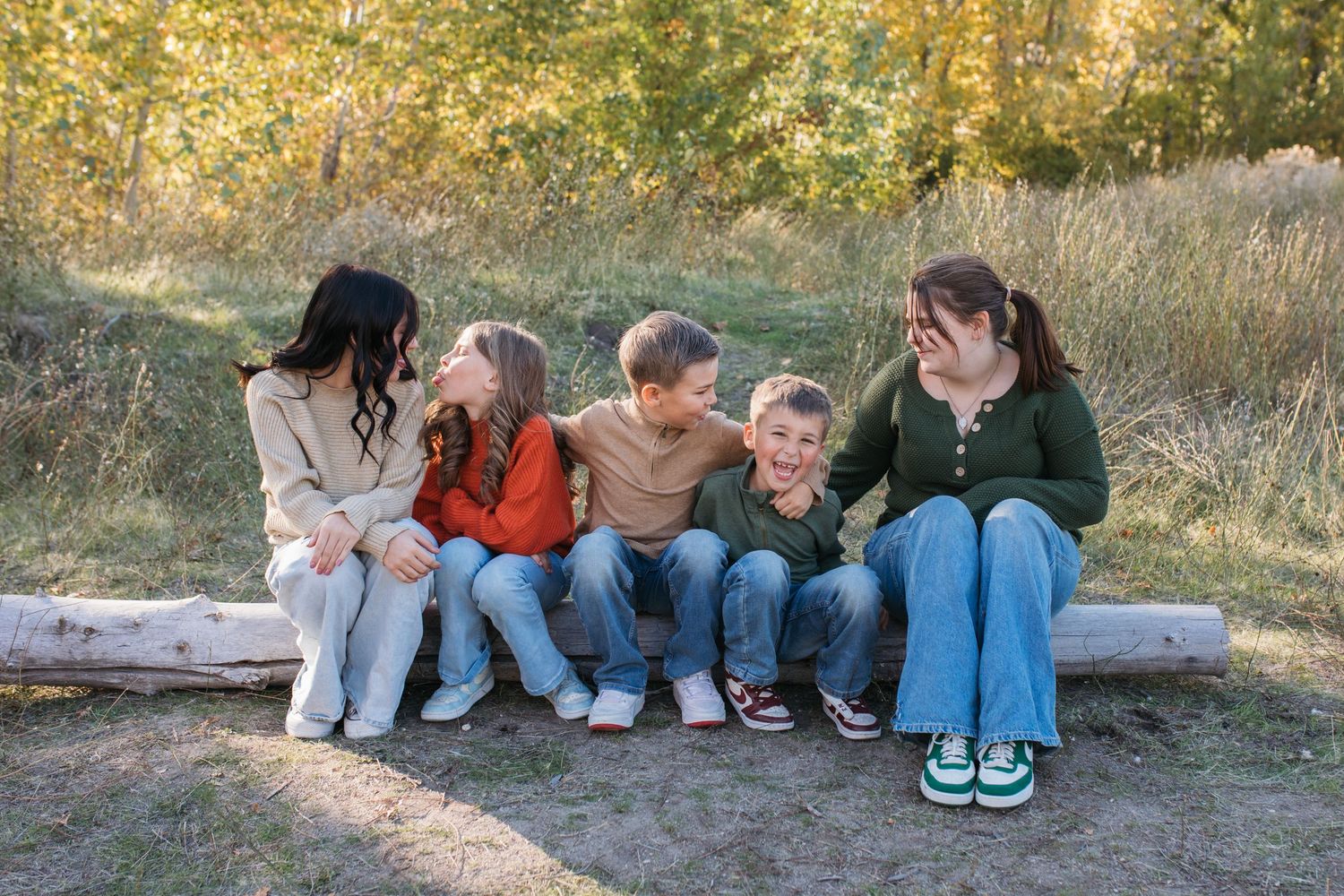 Siblings laughing together during a fall family photography session in Boise, Idaho.