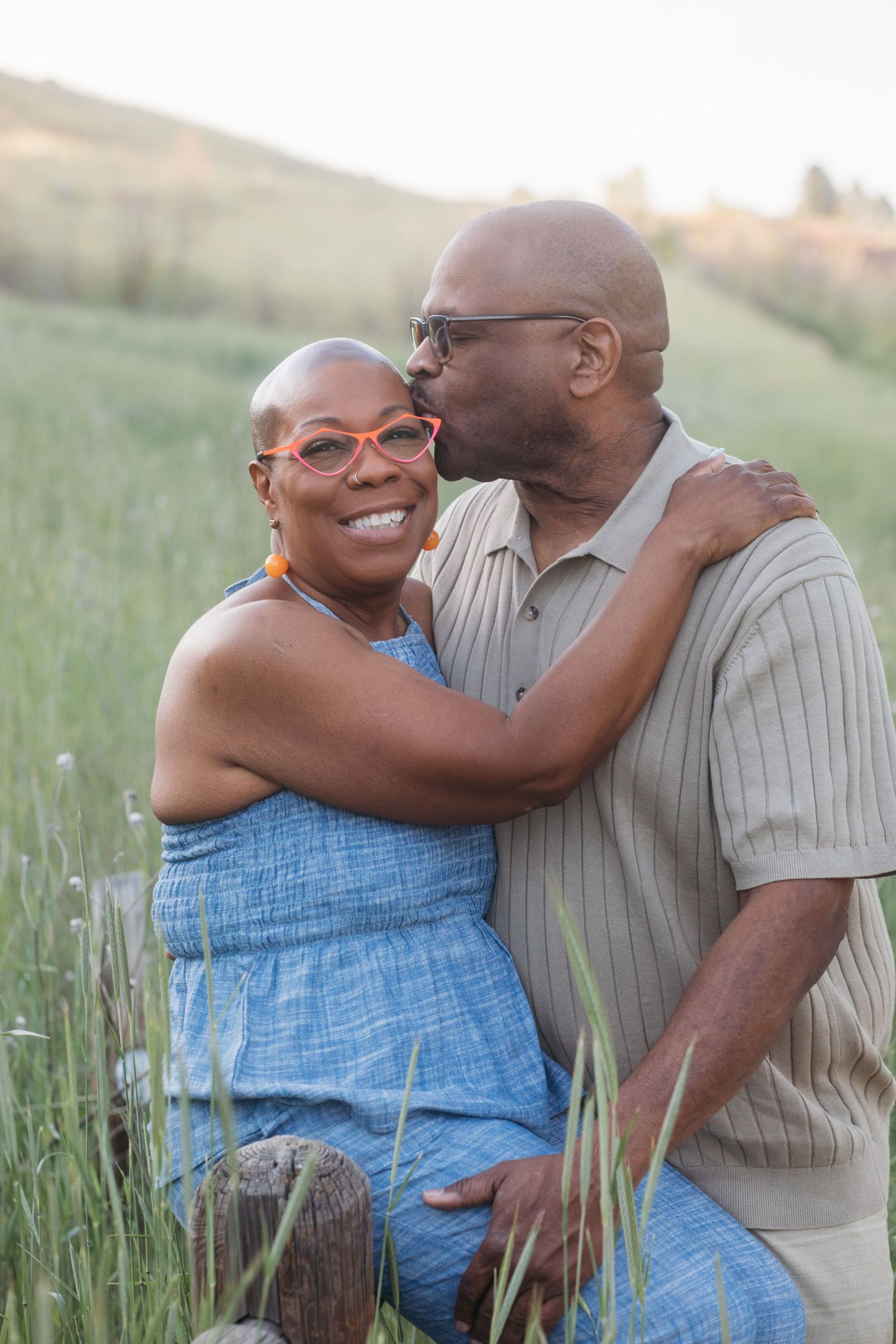 Husband kissing wife on the cheek during a spring extended family photography session at Camel’s Back Park in Boise.