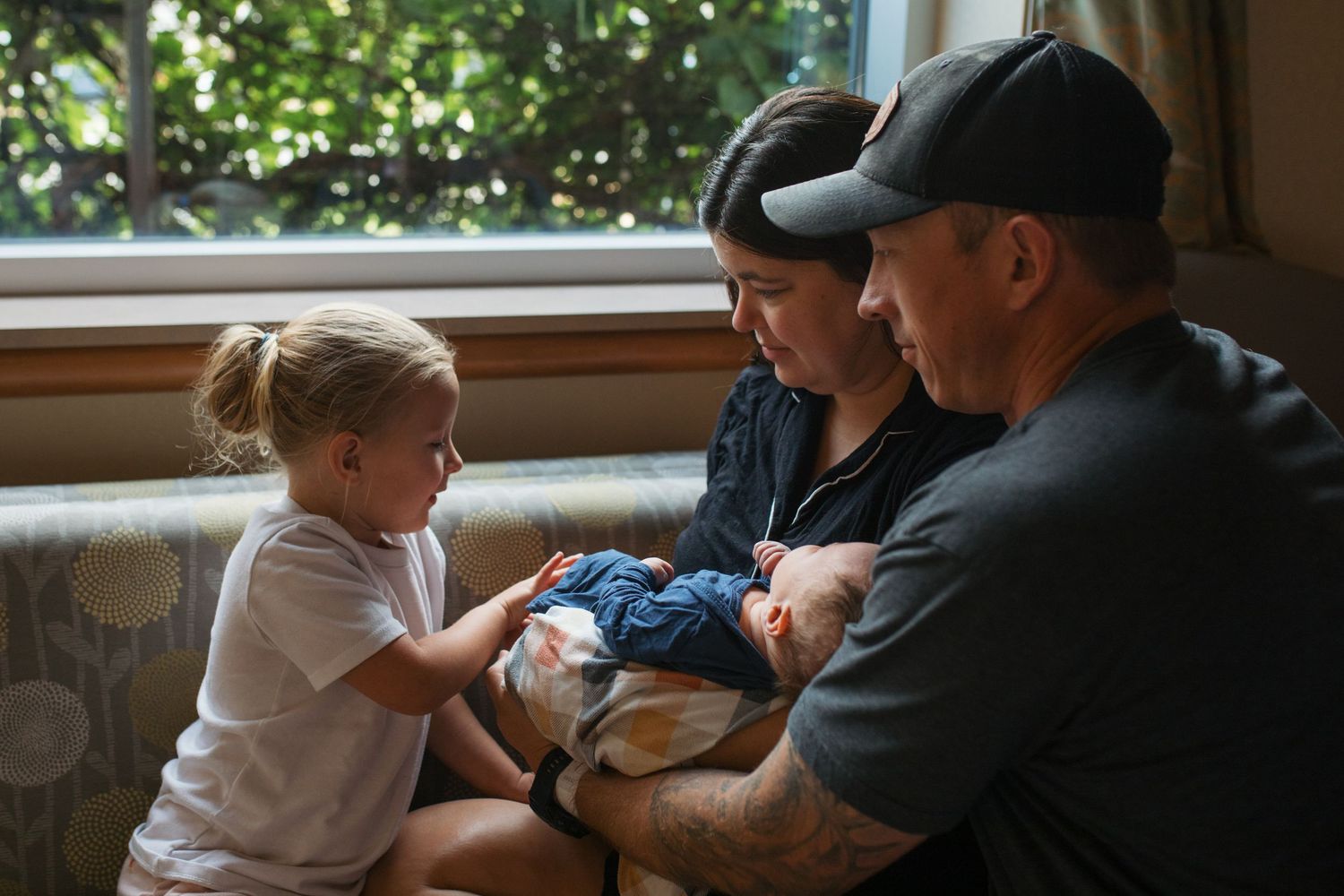 mom and dad showing an older sibling her new baby brother. Fresh 48 session by Sara Elizabeth Photography Boise Idaho