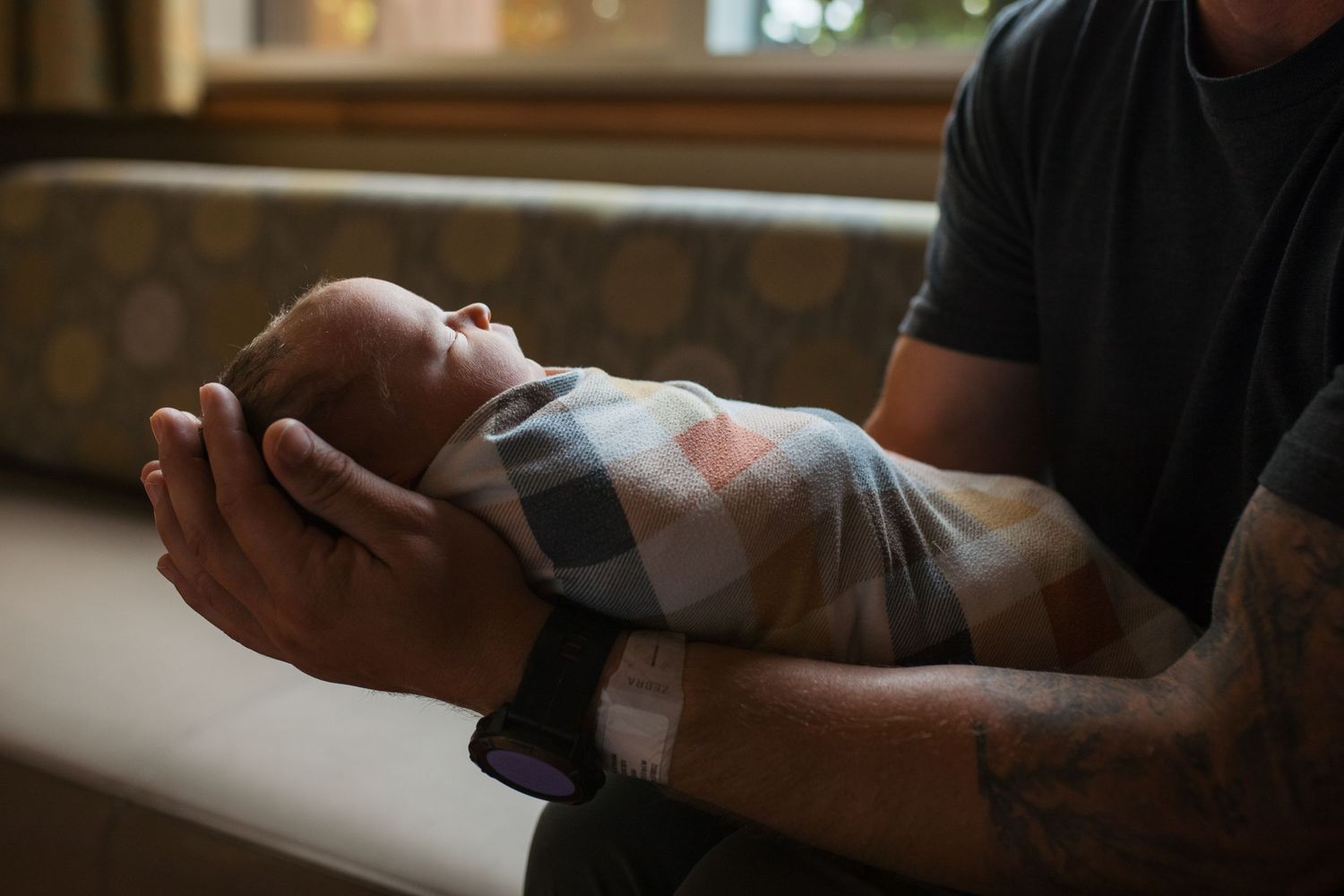 Close up shot of someone gently cradling and comforting a sleeping newborn baby in their arms.