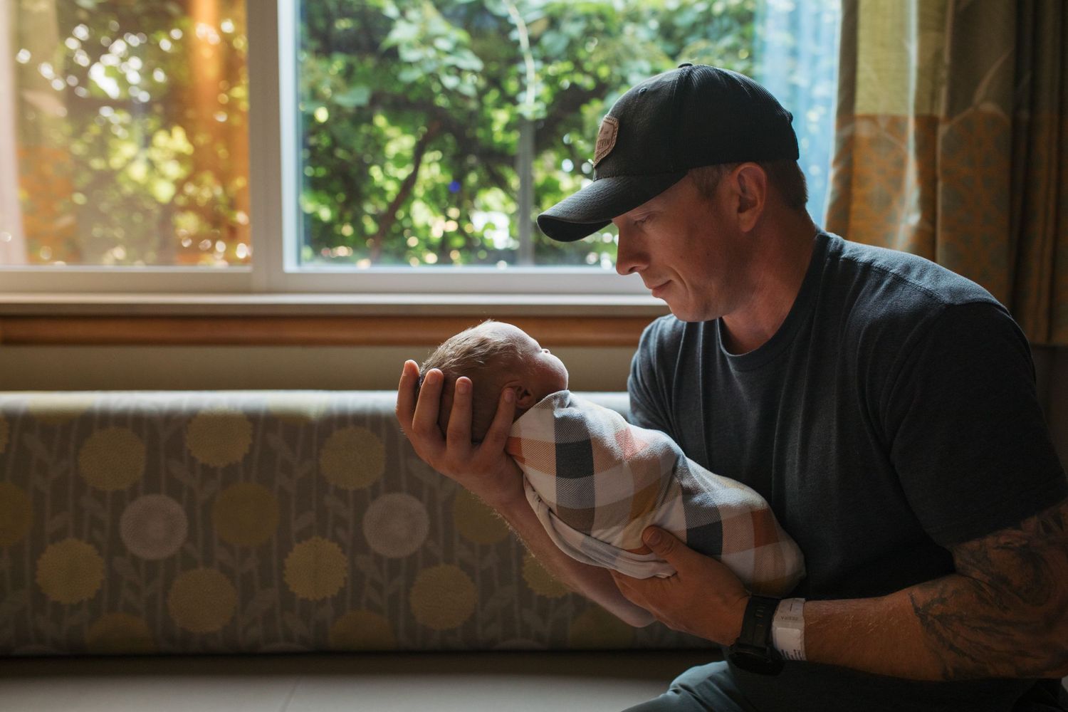 a new dad holding his newborn in the hospital Fresh 48 session by Sara Elizabeth Photography in Boise, Idaho