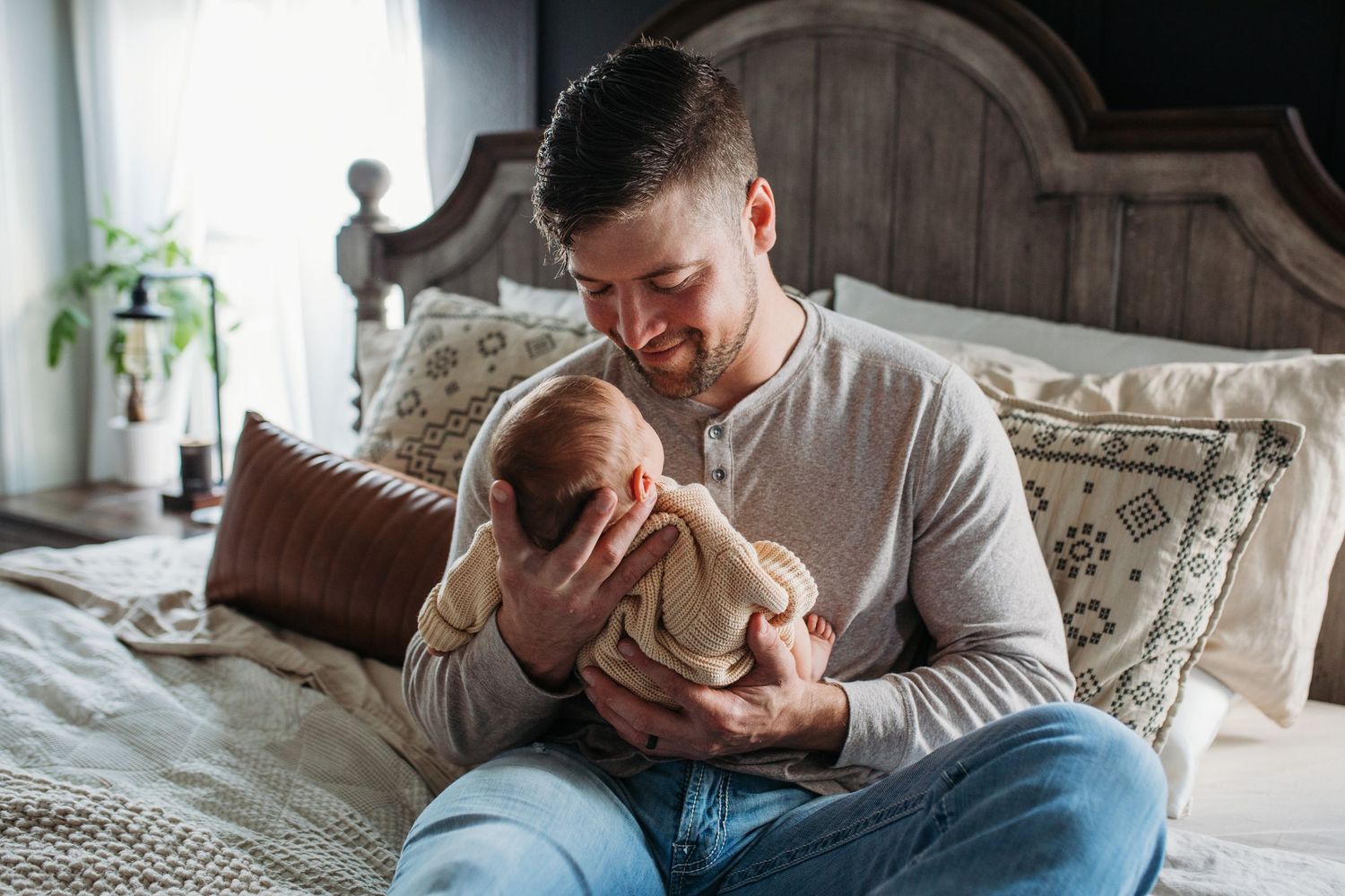Father holding newborn baby during a lifestyle in-home newborn photography session in Boise, Idaho by Sara Elizabeth Photography.