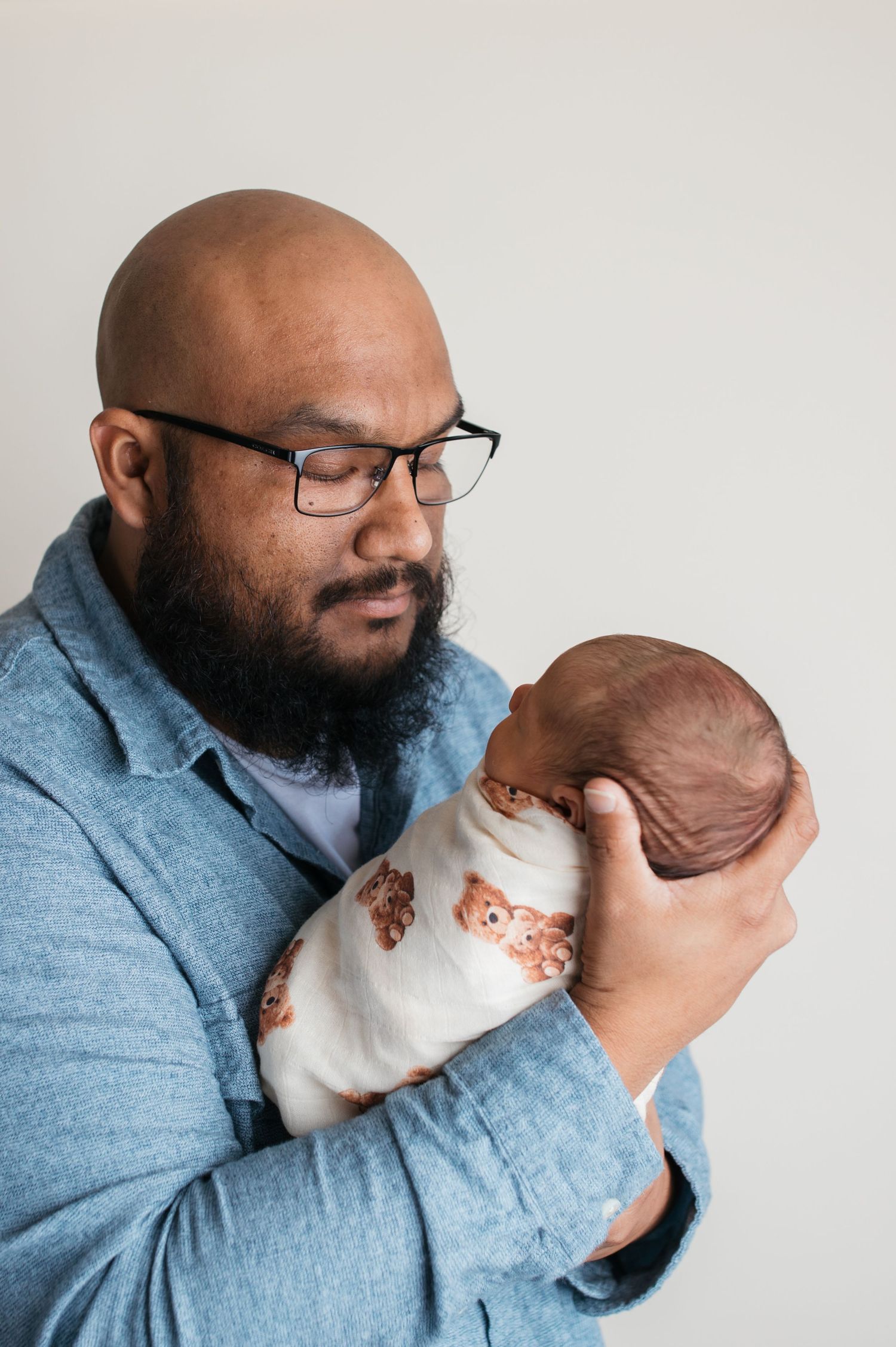 Dad holding newborn baby boy during studio newborn photography session in Caldwell Idaho