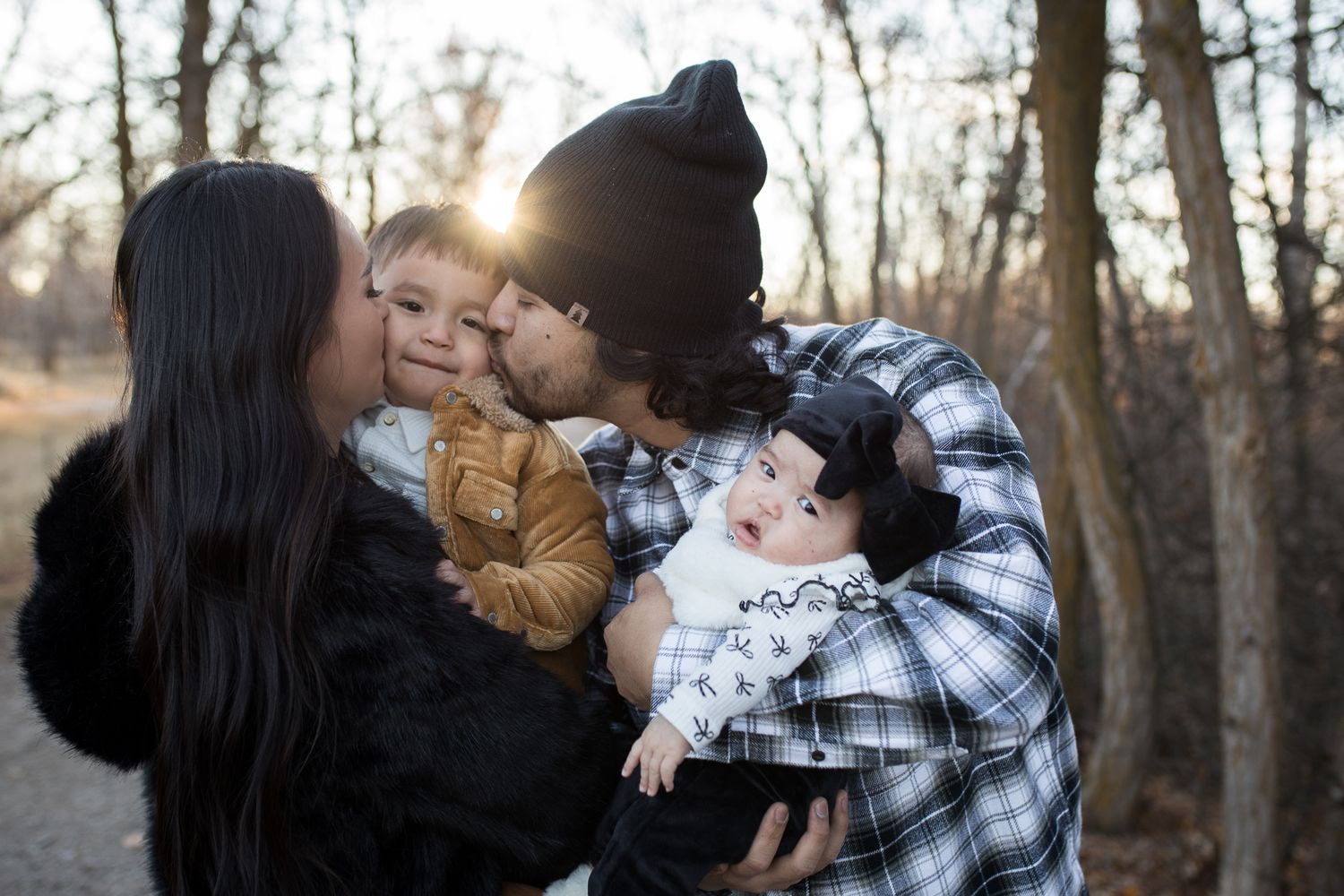 Family members share tender moments together in a wooded area during golden hour sunset - lifestyle family photos in Boise