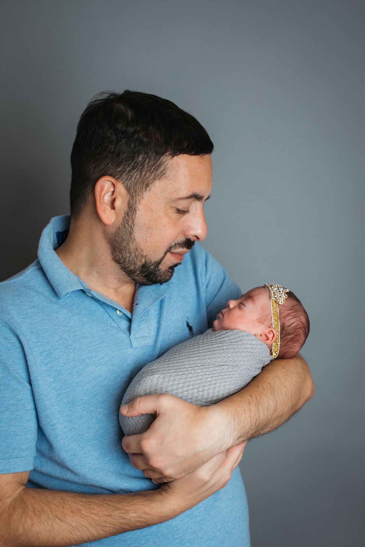 Dad holding his newborn baby girl during a studio newborn session in Nampa, Idaho