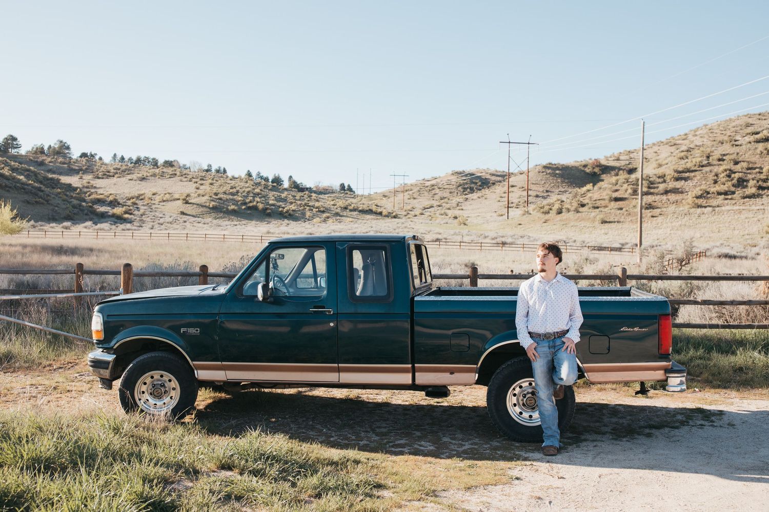 High school senior standing next to truck in wide outdoor Boise Idaho senior photo session