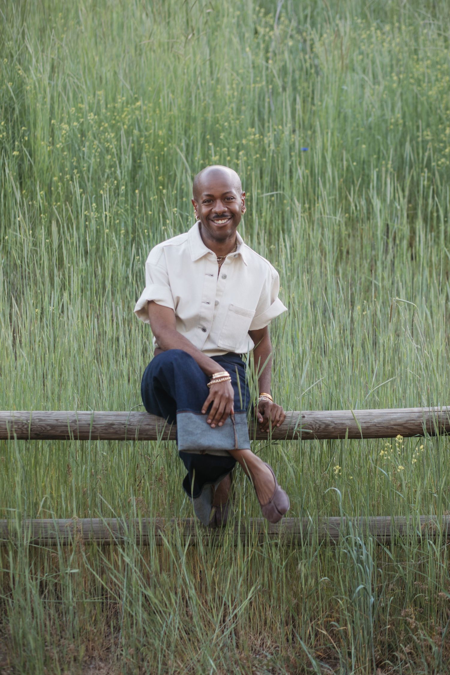 Man sitting on a wooden fence during an extended family photography session at Camel’s Back Park.
