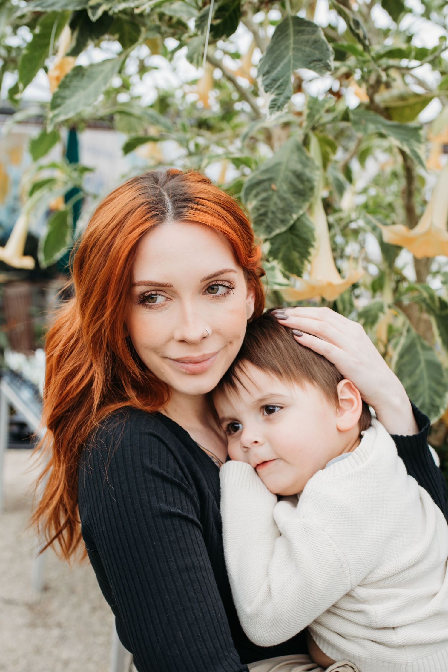 Mother holding her child inside a greenhouse during a Boise family photography session.