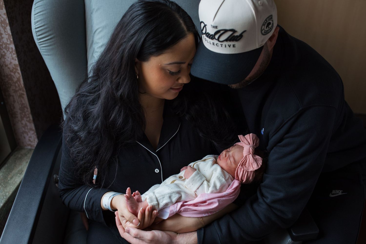 Parents holding newborn baby girl in hospital room during Boise Fresh 48 photography session