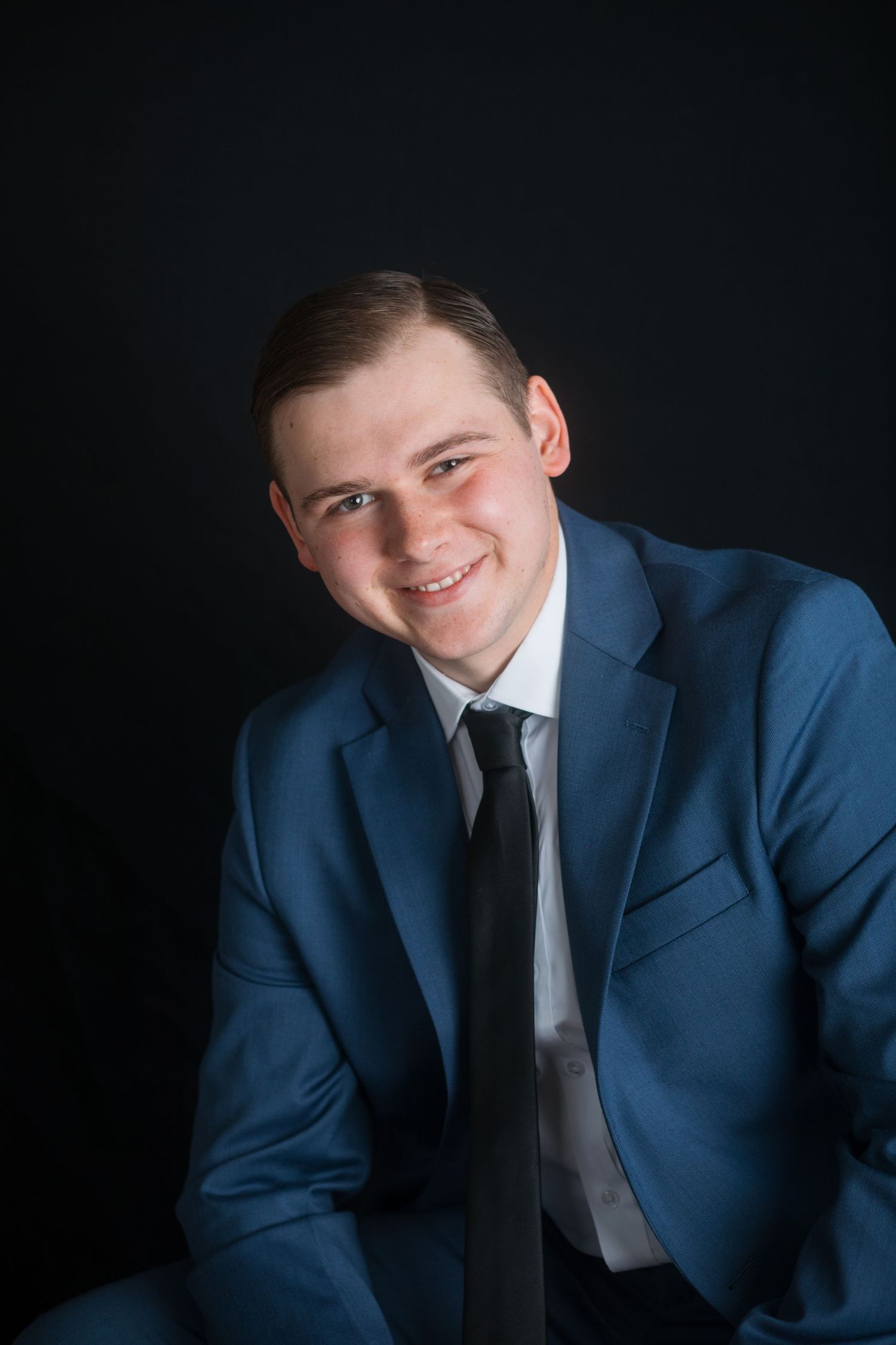 Studio headshot of young man in blue suit with confident smile, Boise Idaho photographer