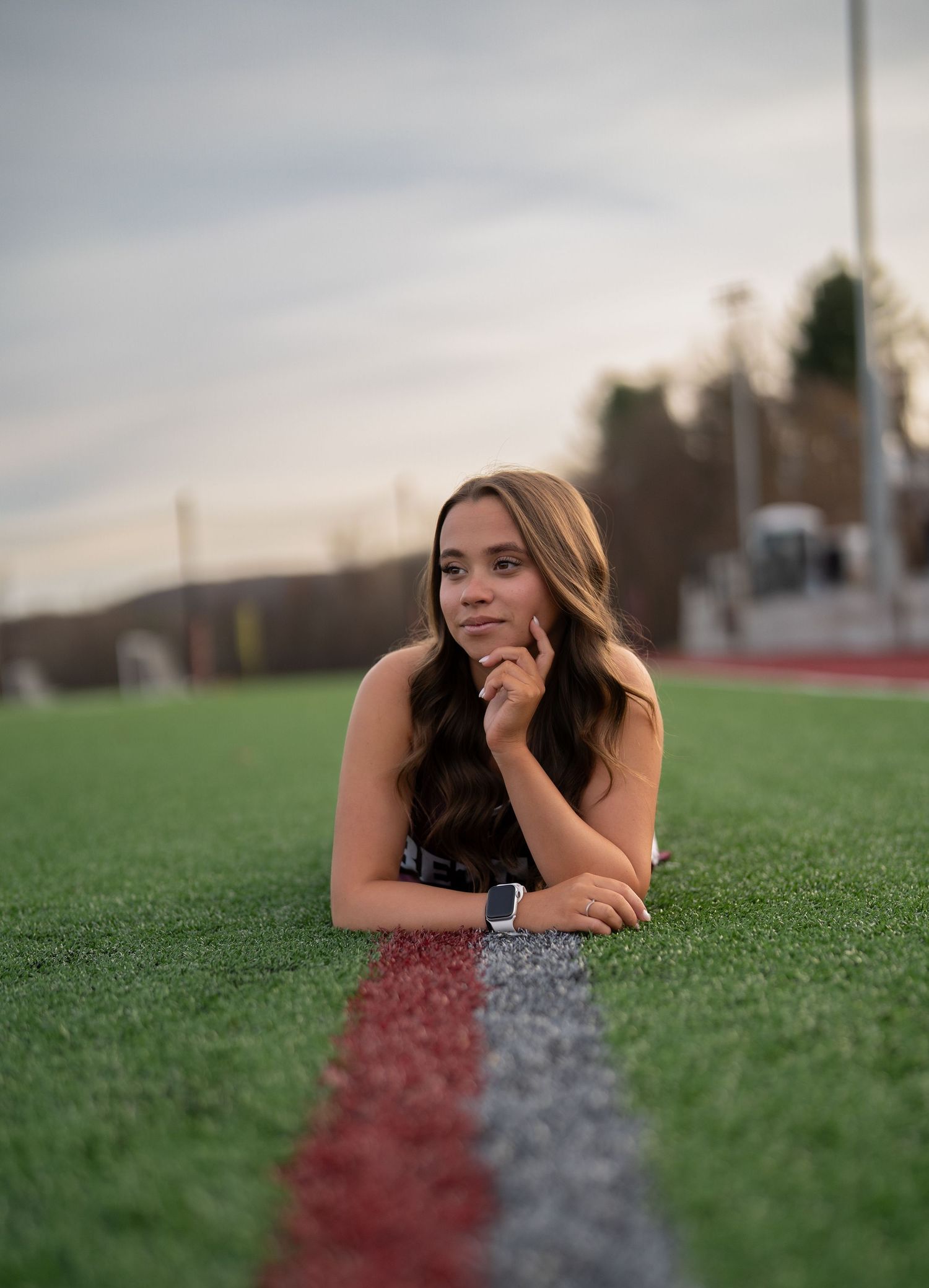 Person lying on sports field turf creating artistic portrait with selective focus effect.
