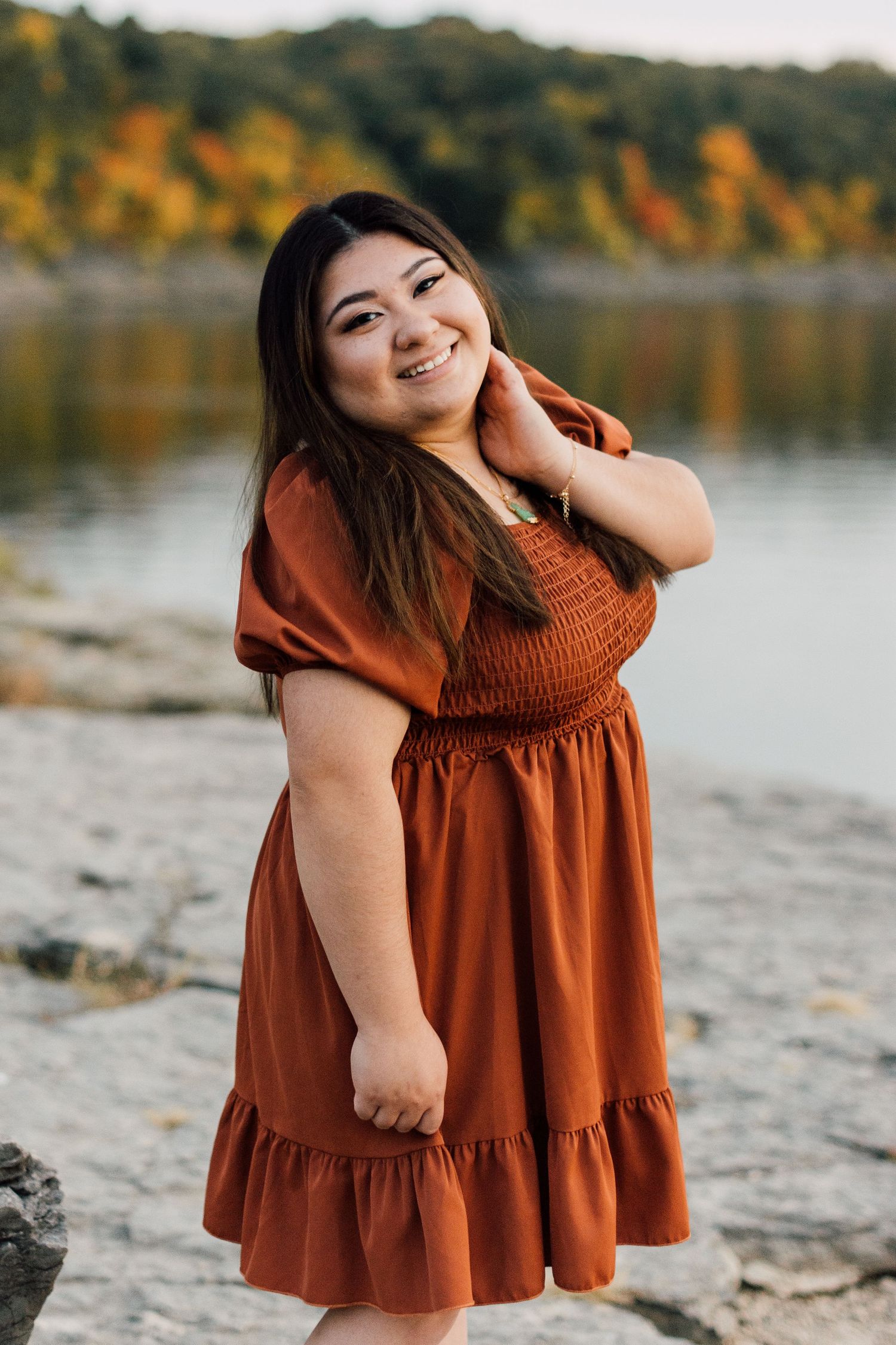 A series of outdoor portrait photos in a rust-colored dress against a lakeside backdrop.