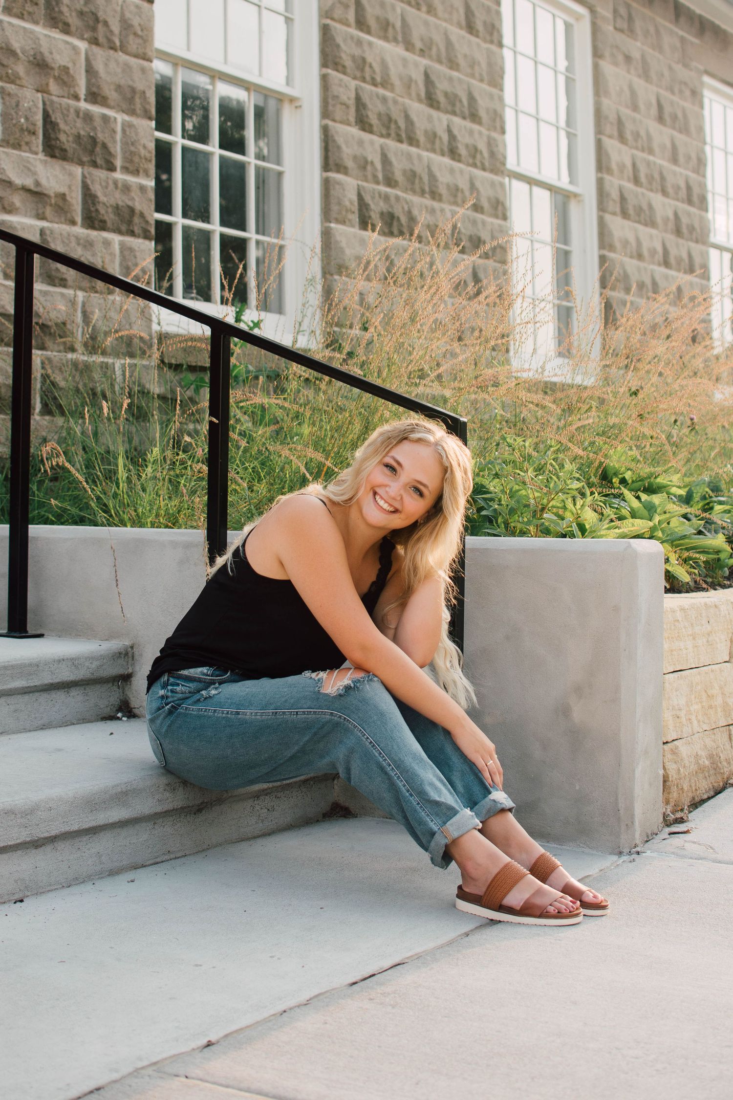 Playful poses on concrete steps against a stone building exterior.