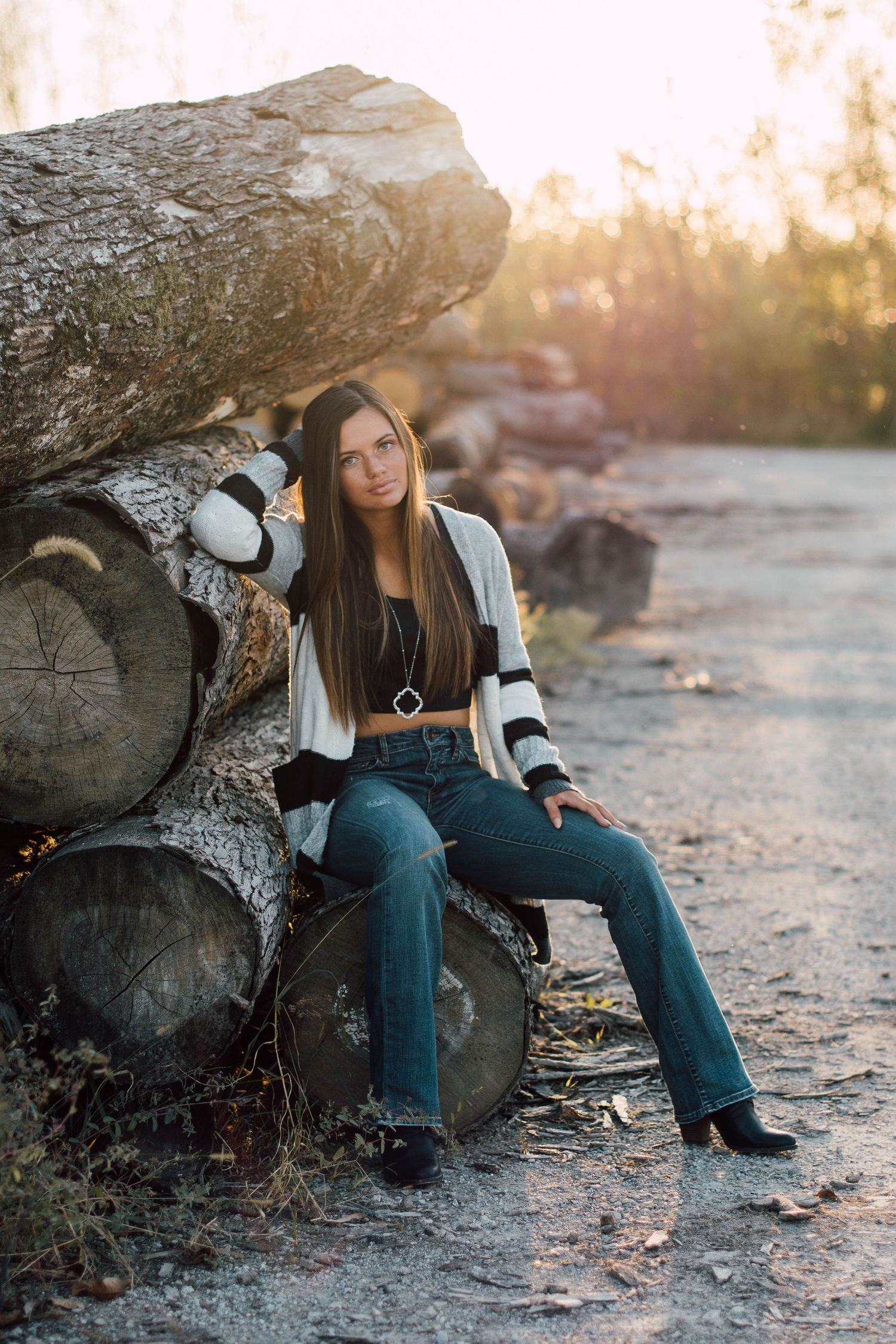 Person wearing headphones sits on rocky terrain during golden hour photoshoot.