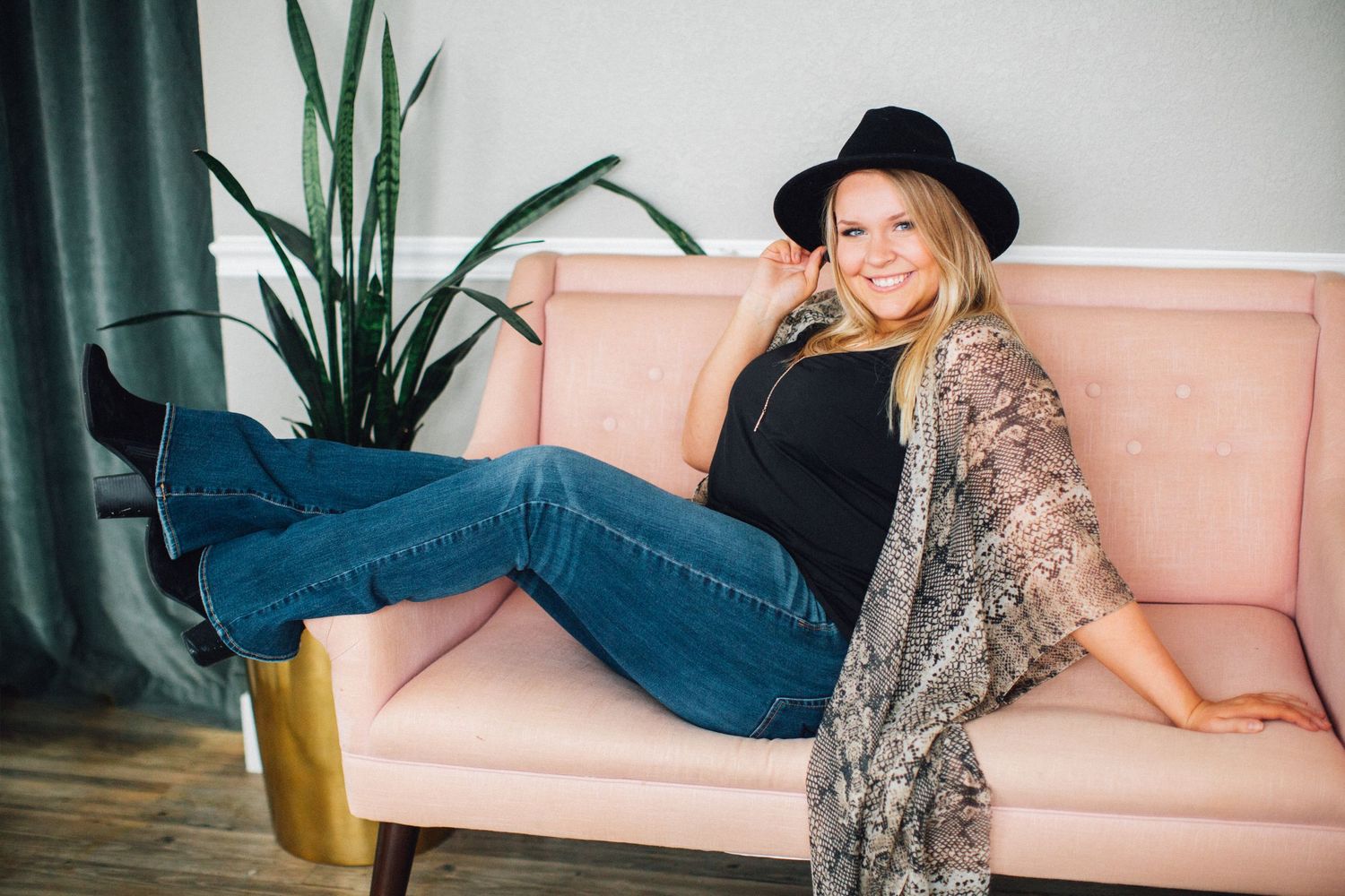 Lifestyle photography session on pink couch with indoor plants.