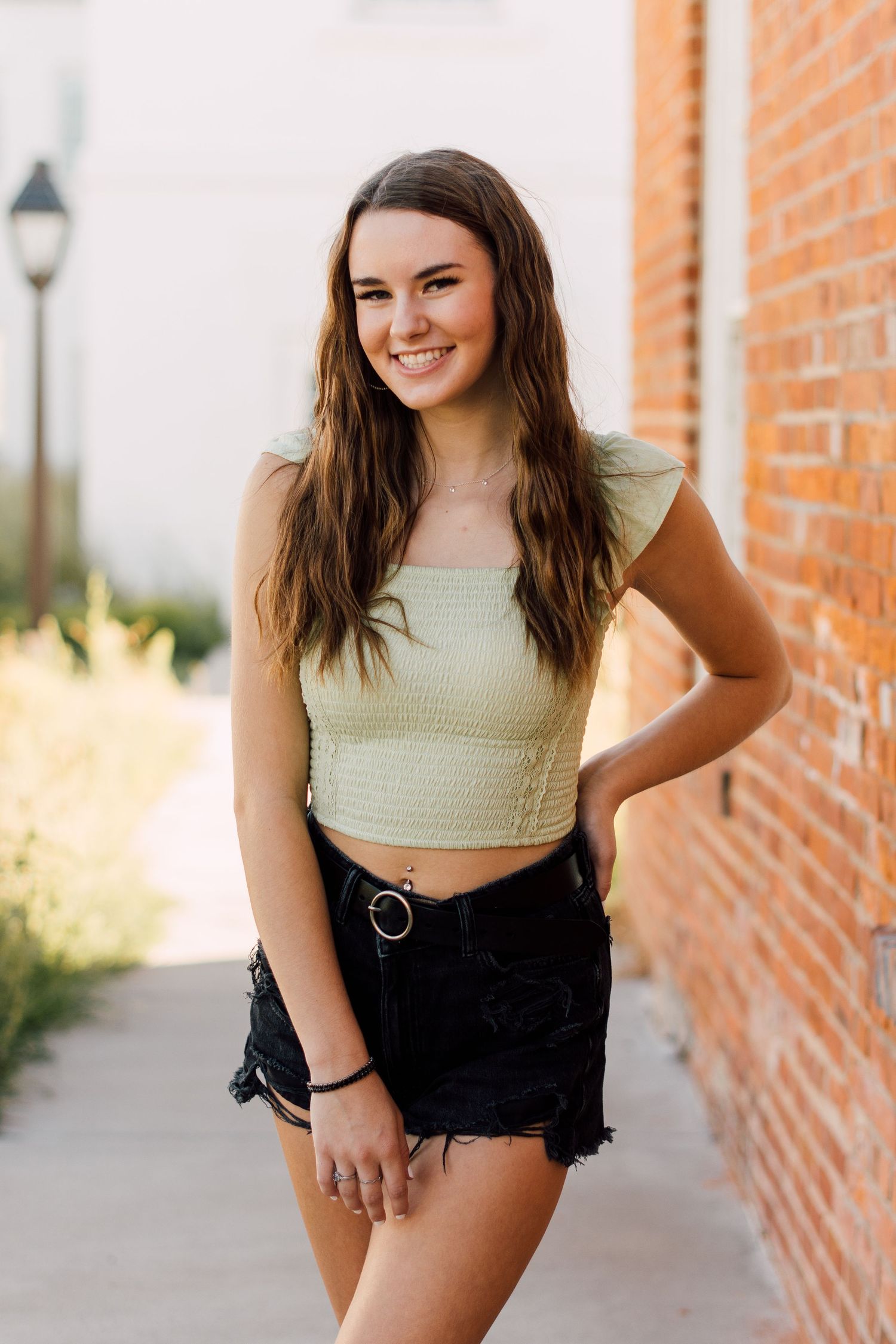 Urban portraits against brick walls featuring casual summer style and natural poses.