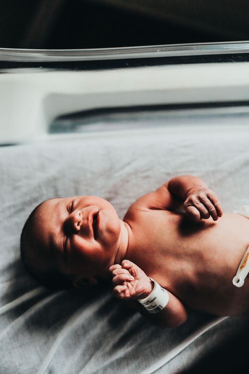 Black and white portrait of newborn baby lying on soft bedding. Baby photos Vigo County professional fine art local photographer