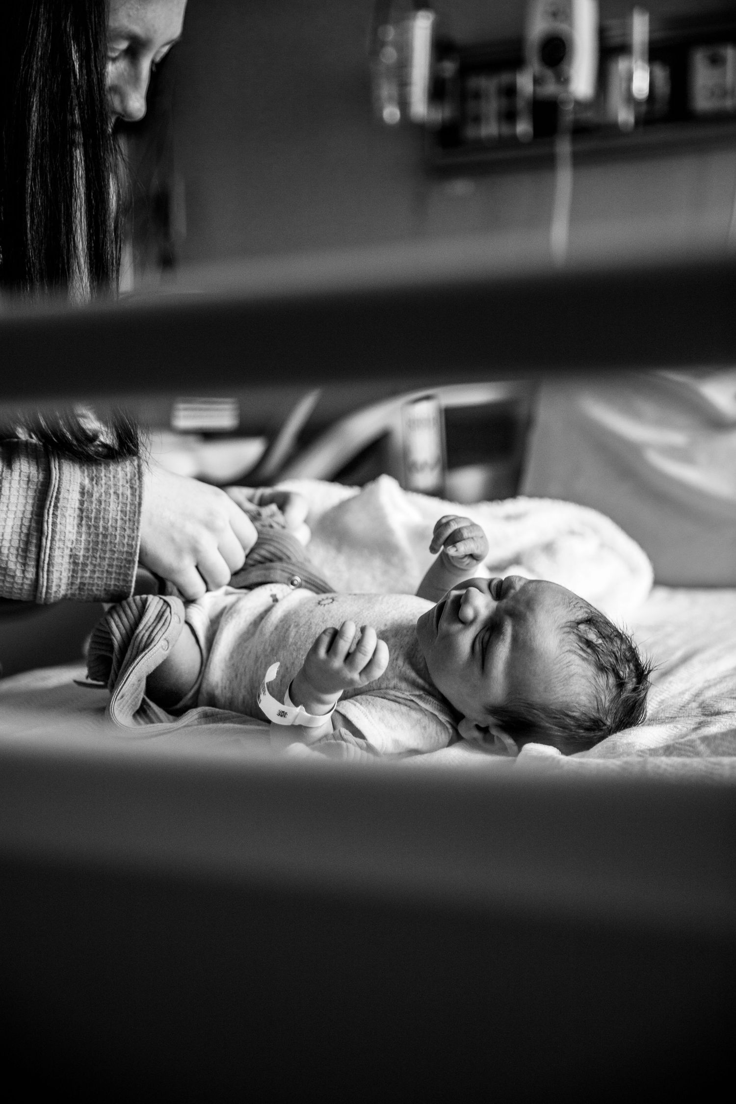 Black and white image of a newborn baby being changed during a professional photography session at local hospital. Rockville Indiana