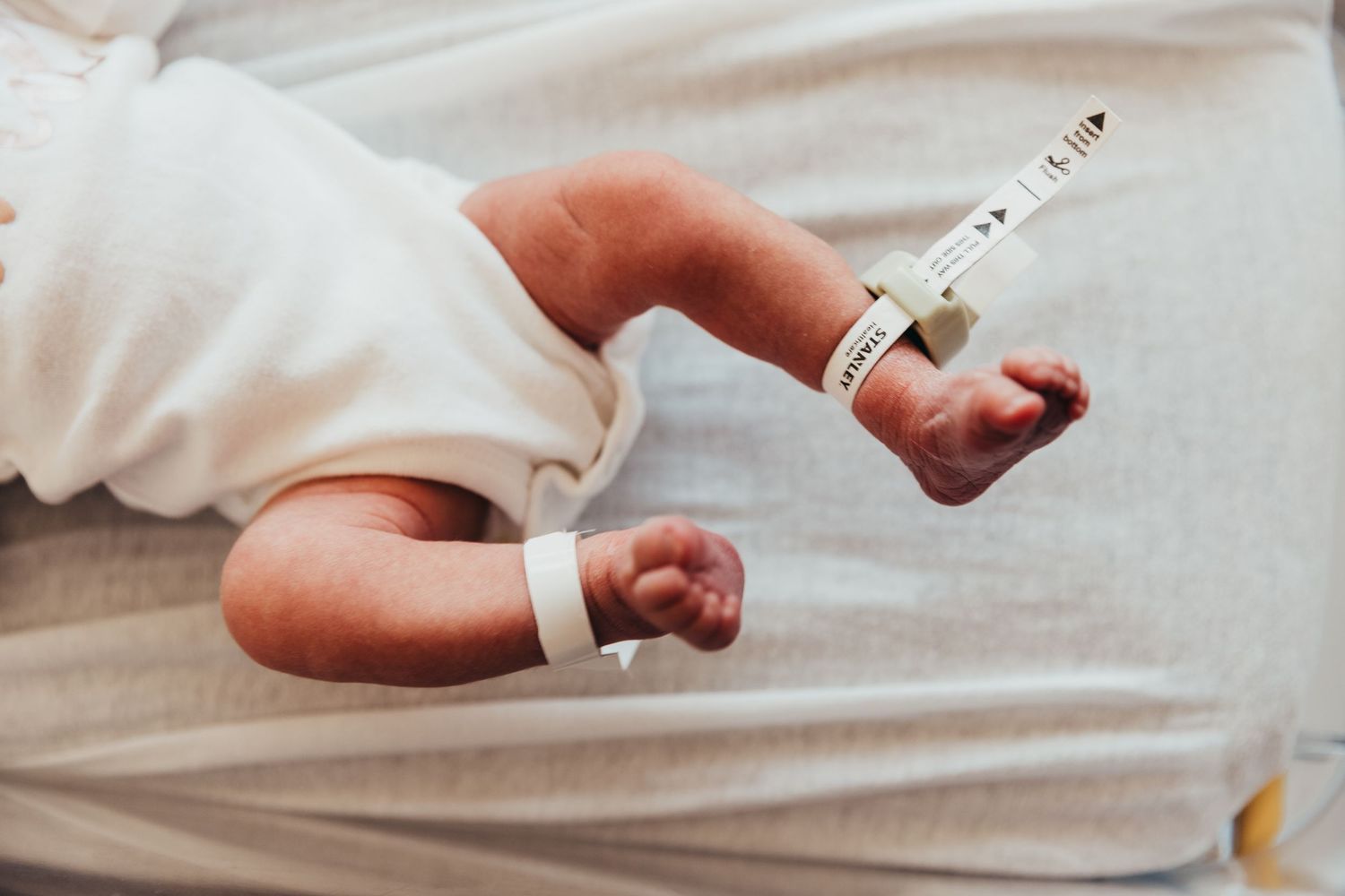 White ceramic ring displayed on a model's hand against a light background. Union Hospital Terre Haute Newborn Baby Professional Photos