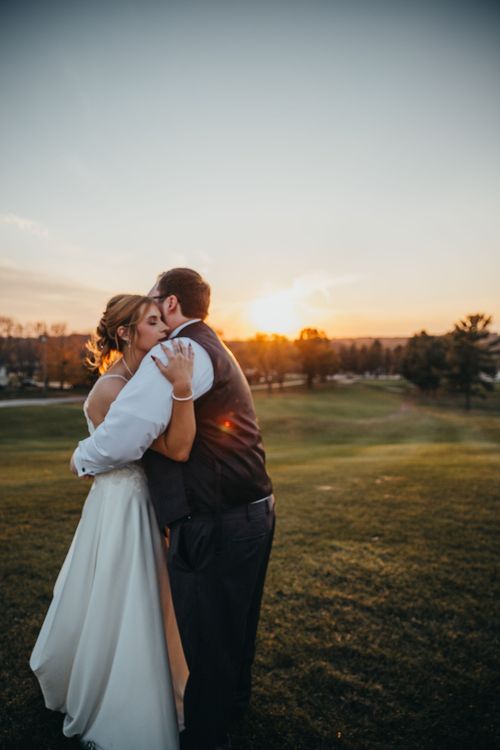 Newlywed couple embracing during sunset on golf course in romantic moment. Wedding photos Greencastle