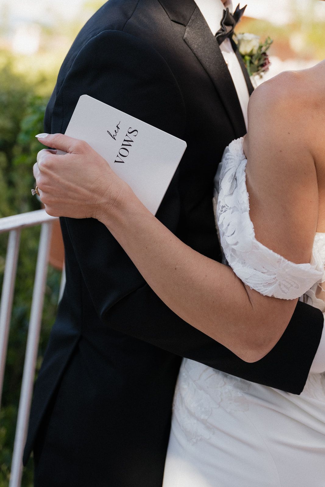 Close-up of a couple holding vow books during an outdoor wedding ceremony.